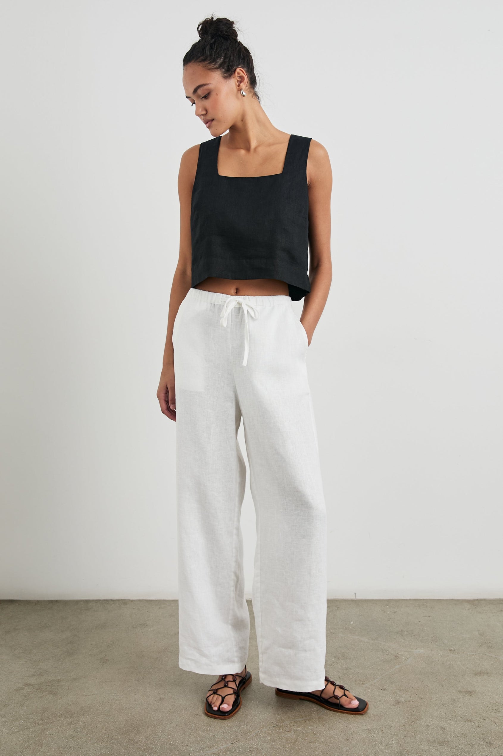Akira Sleeveless Crop Top with Square Neckline and Wide Shoulder Straps in Black Colorway - Front Full Body View Featured on Model