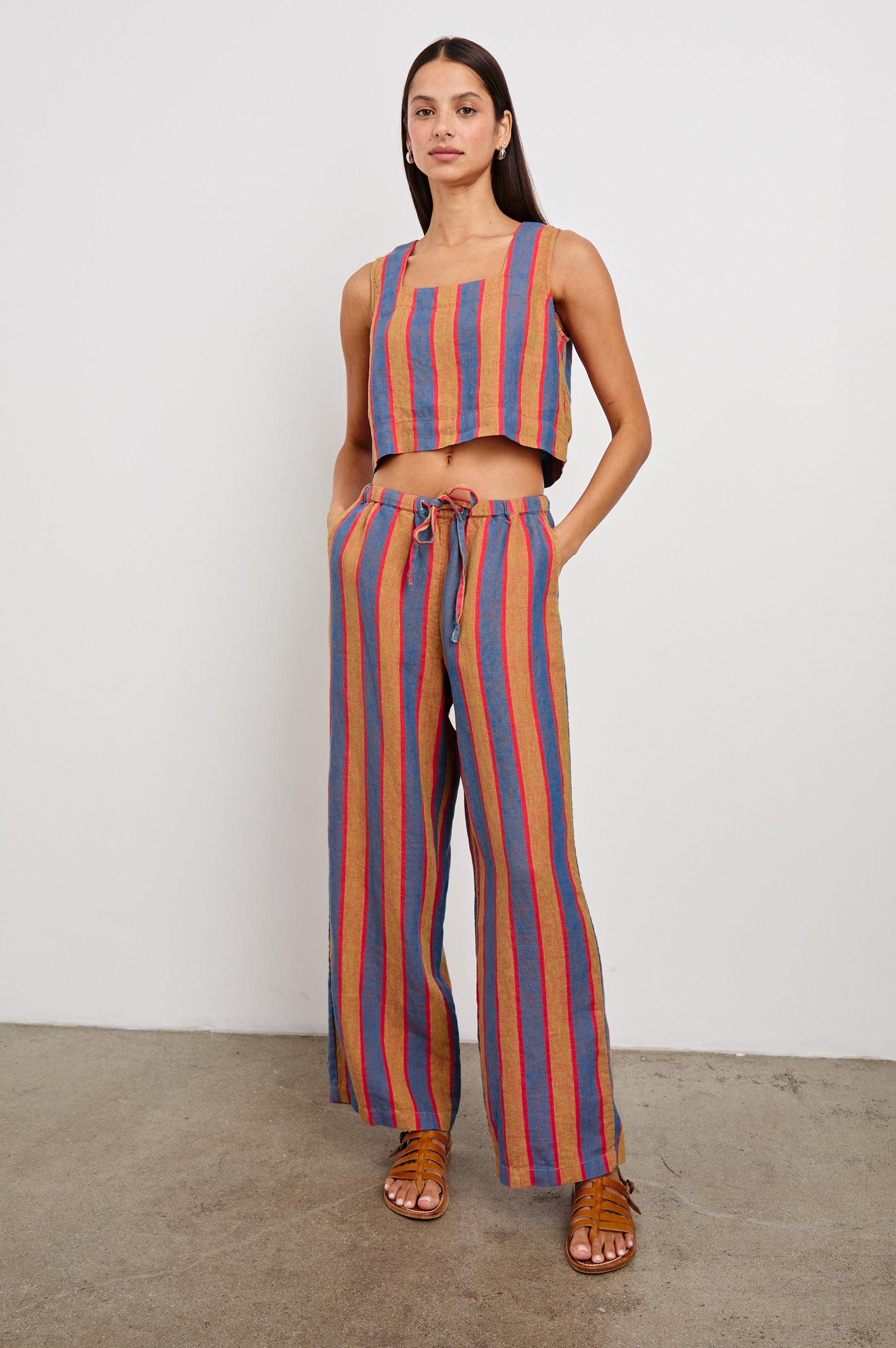 Akira Sleeveless Crop Top with Square Neckline and Wide Shoulder Straps in Rio Stripe Colorway, Vertical Stripes in Tan, Blue, and Pink - Front Full Body View Featured on Model