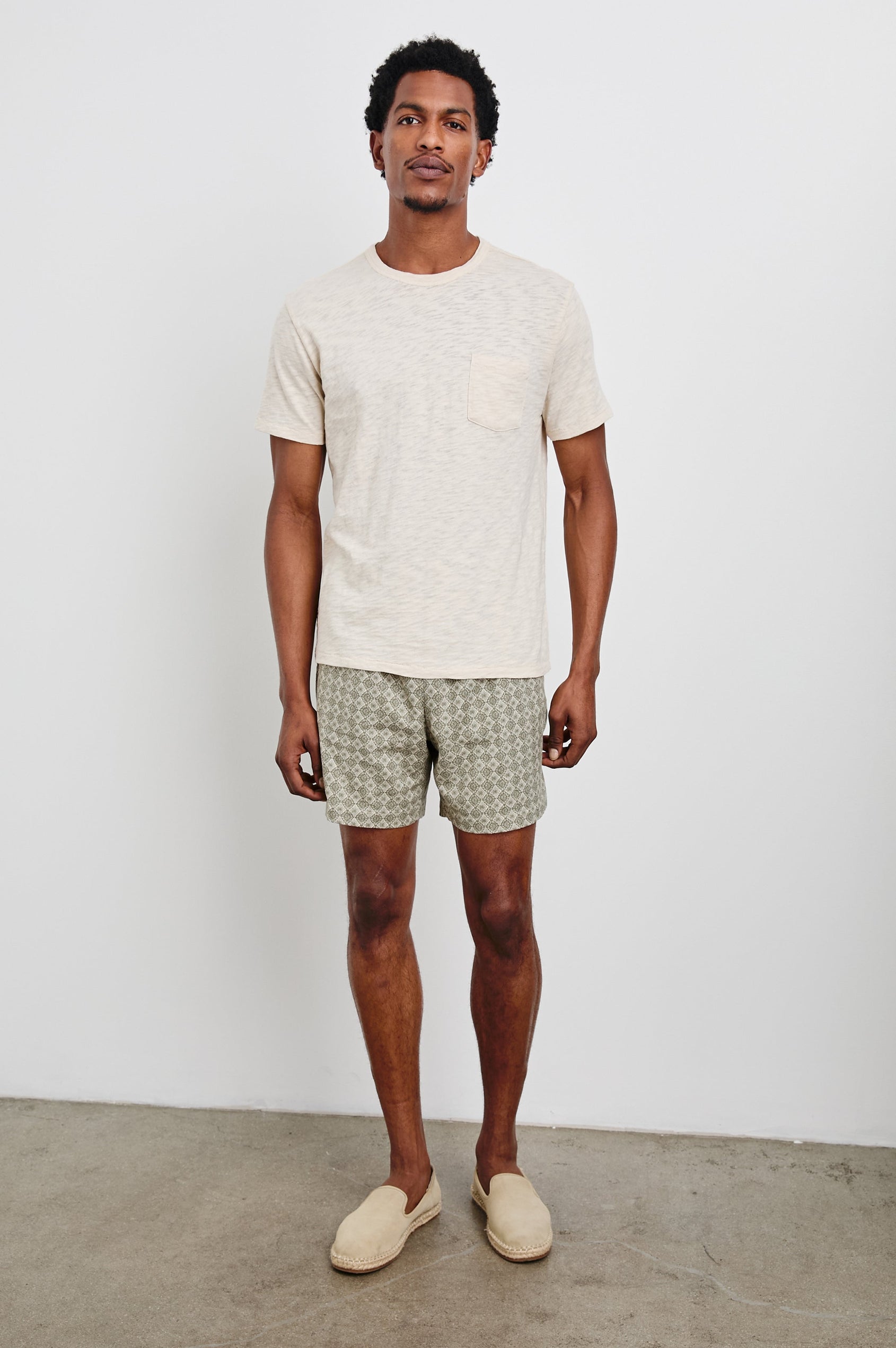 Aries mid length linen short in Diamond Oat Olive art deco pattern - full body front view on model