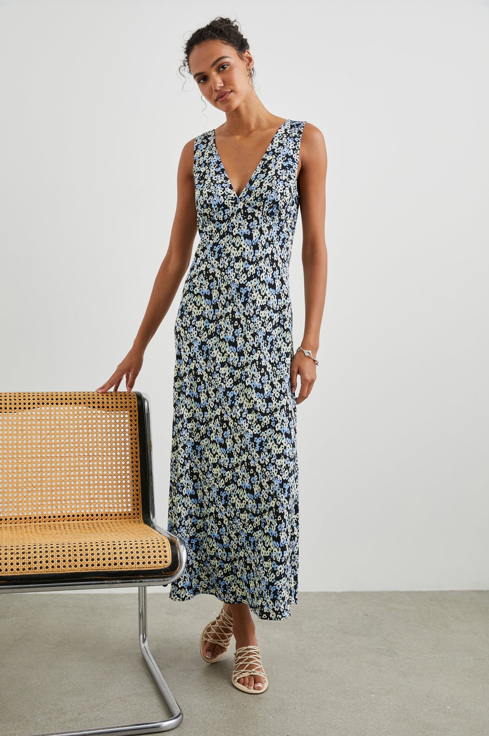 Audrina Sleeveless Midi Dress with Wide Shoulder Straps, a Deep V Neck and V-Back, and an Empire Waist in Midnight Meadow Floral Colorway, cream and blue flowers on Midnight - Front Full Body View Featured on Model