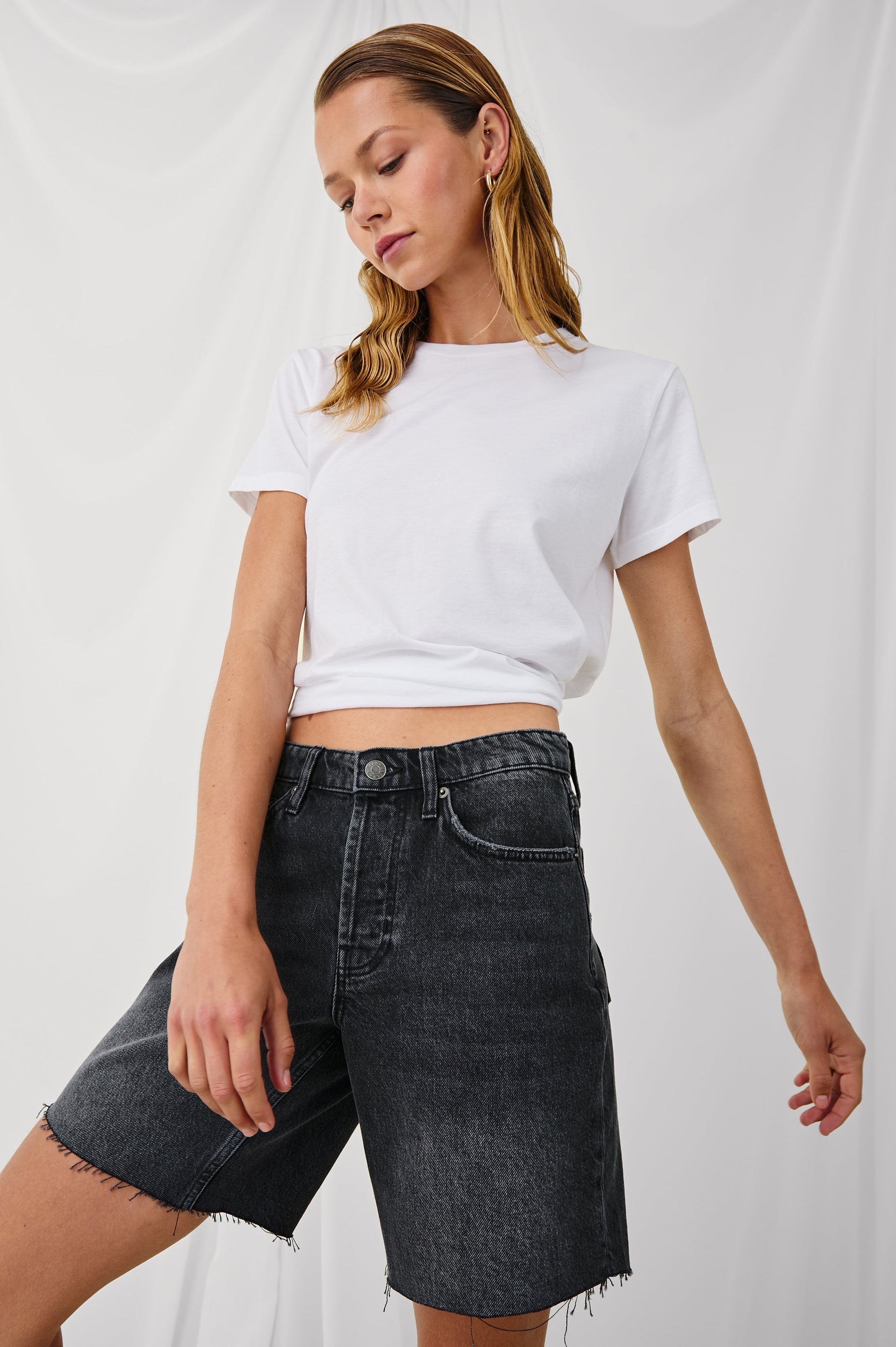 Beachwood high rise bermuda length denim short in dark wash Black Smoke - front view on model, looking down with arms in motion