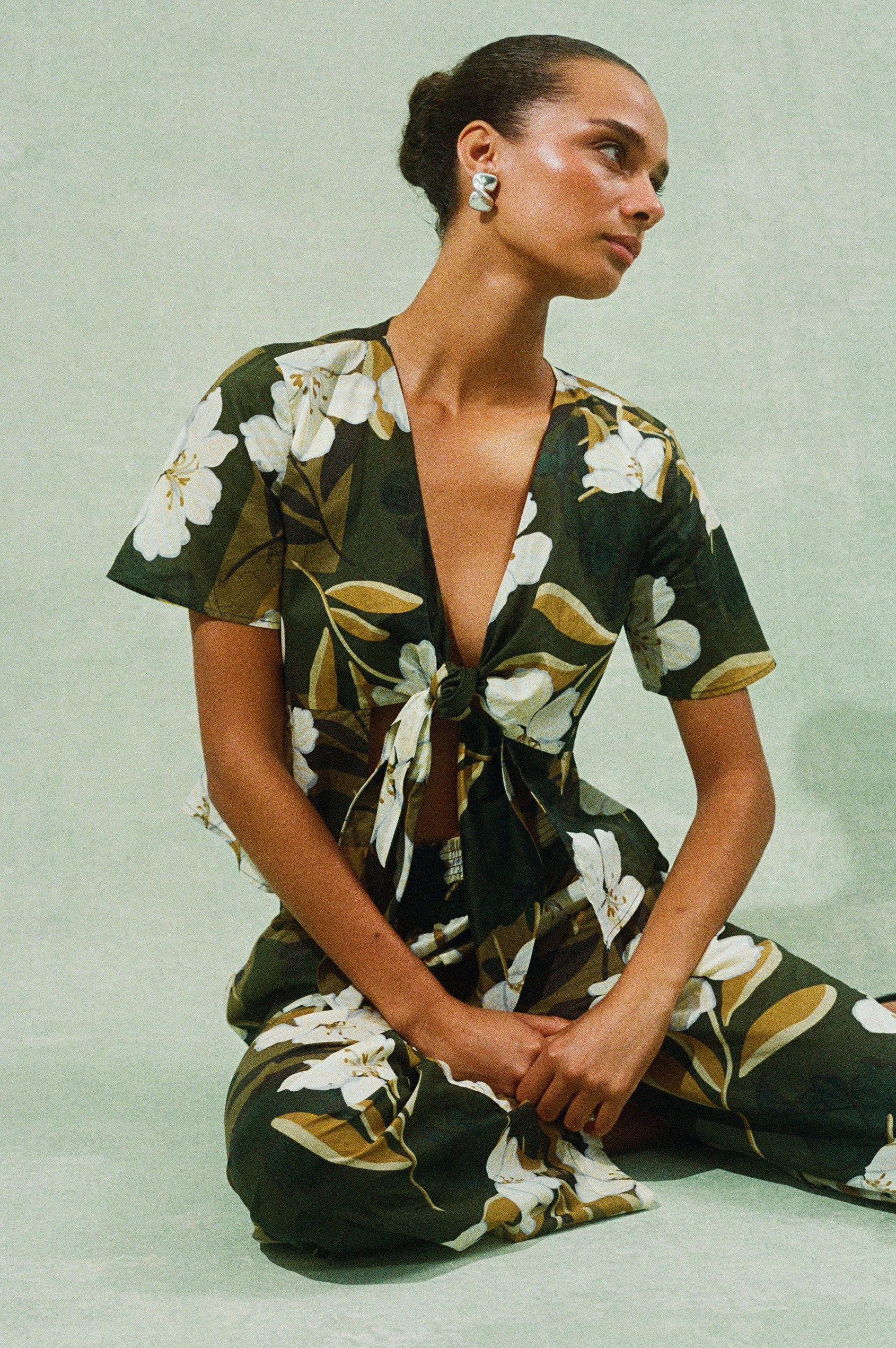 Brendon full length Pant in Plumerias tropical floral print with elastic waistband - on model sitting on ground