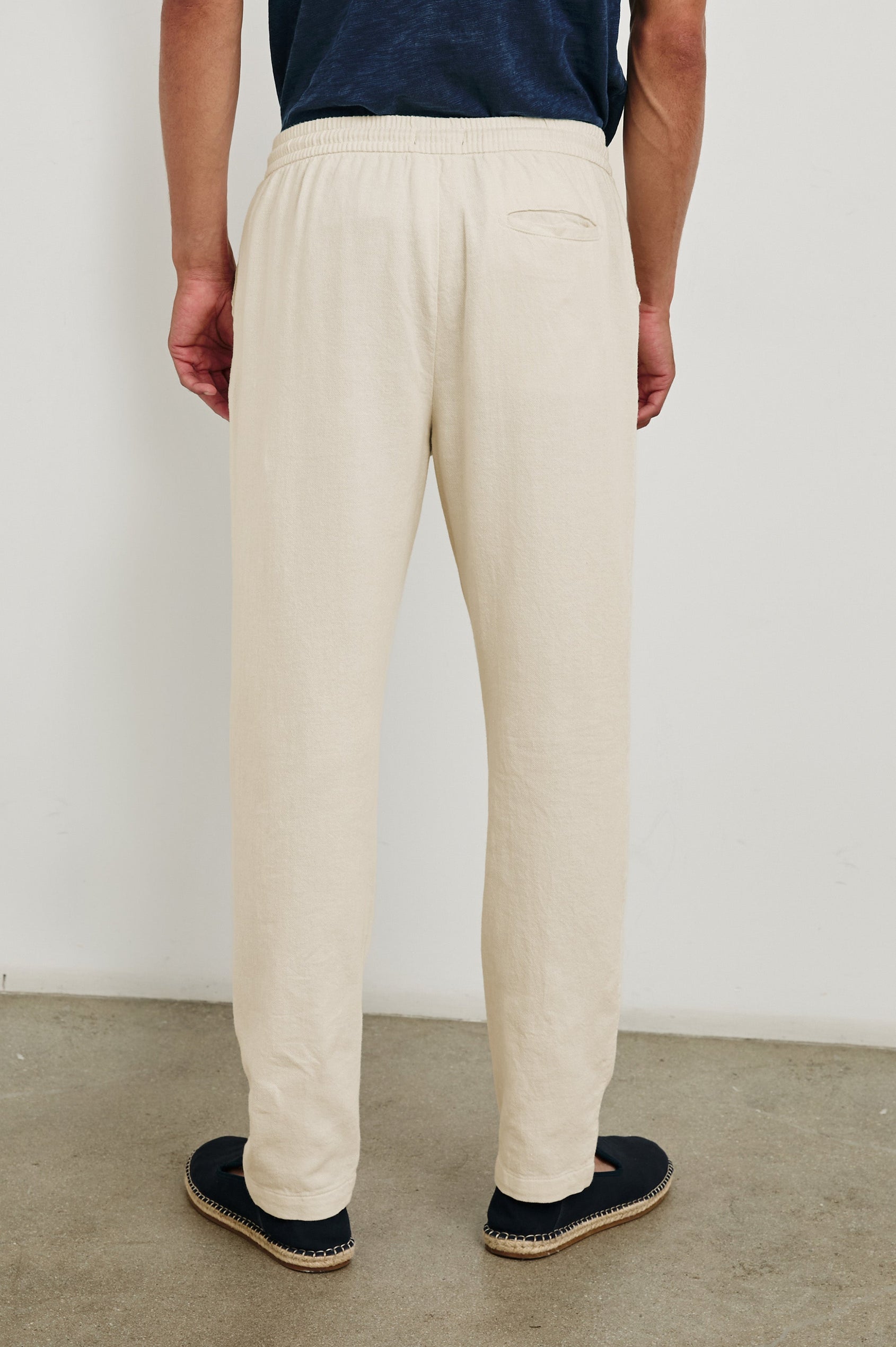 Callum extended length linen straight leg pant with elastic waistband and adjustable drawstring in Ecru - back view on model