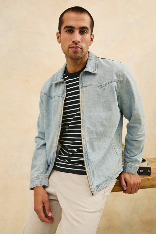 Cooke western style zip-up jacket with contrast stitching details in Light Wash - stylized front view on model, leaning on desk
