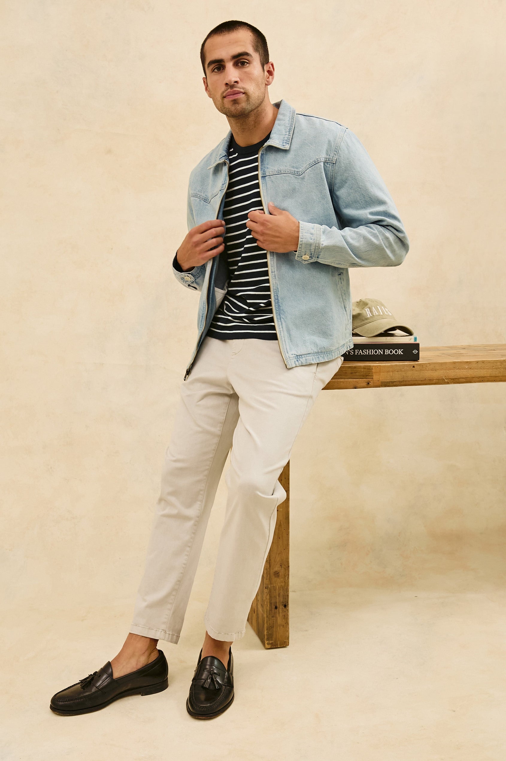 Cooke western style zip-up jacket with contrast stitching details in Light Wash - full body front view on model, stylized leaning on desk