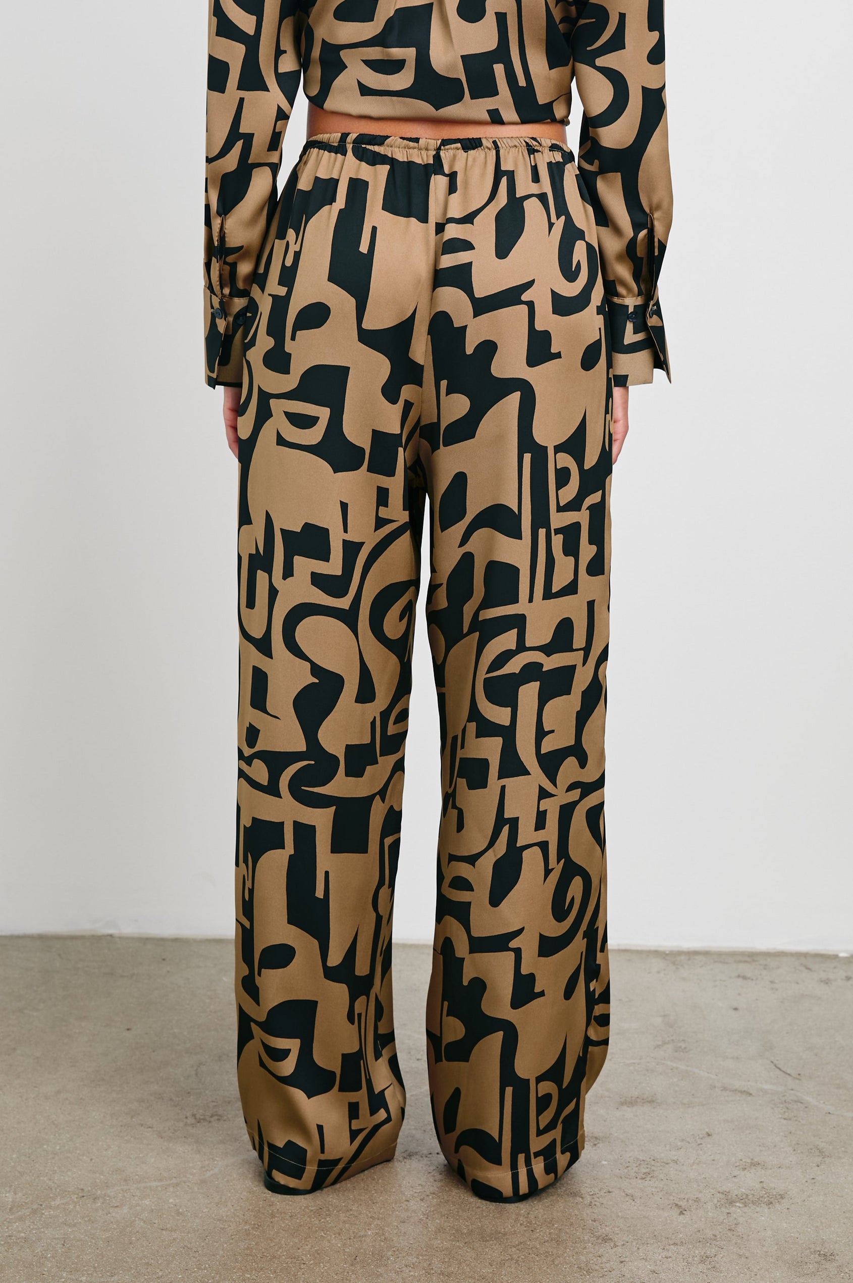 Damini Pants with a Drawstring Waist and Two Front Pockets in Santorini Sand Colorway, a Sand and Black pattern - Back View Featured on Model