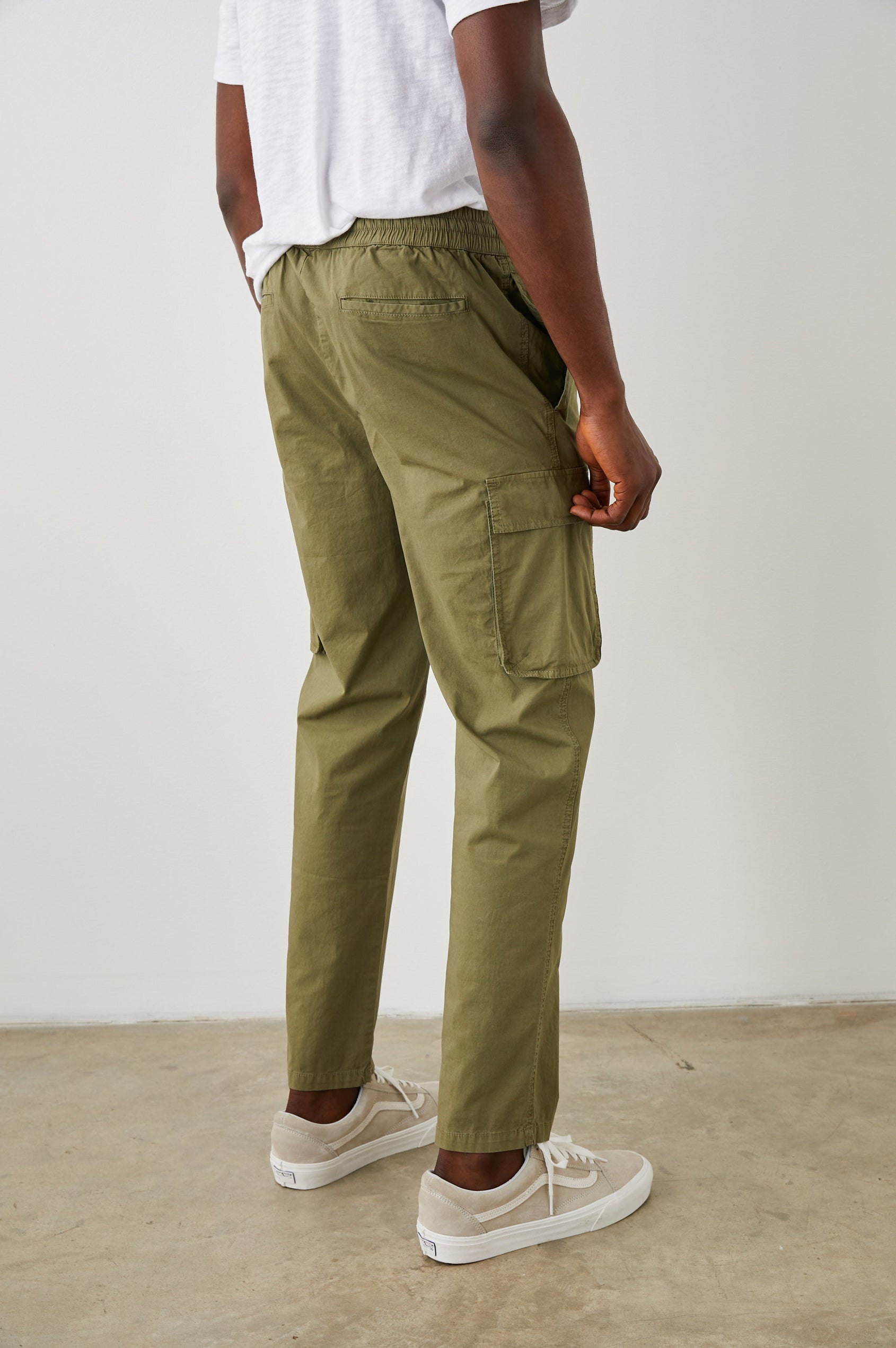 Emmerson Pants with a Drawstring Waist, Two Front Pockets, Two Side Flap Pockets and Two Back Welt Pockets in Olive Colorway - Back View Featured on Model