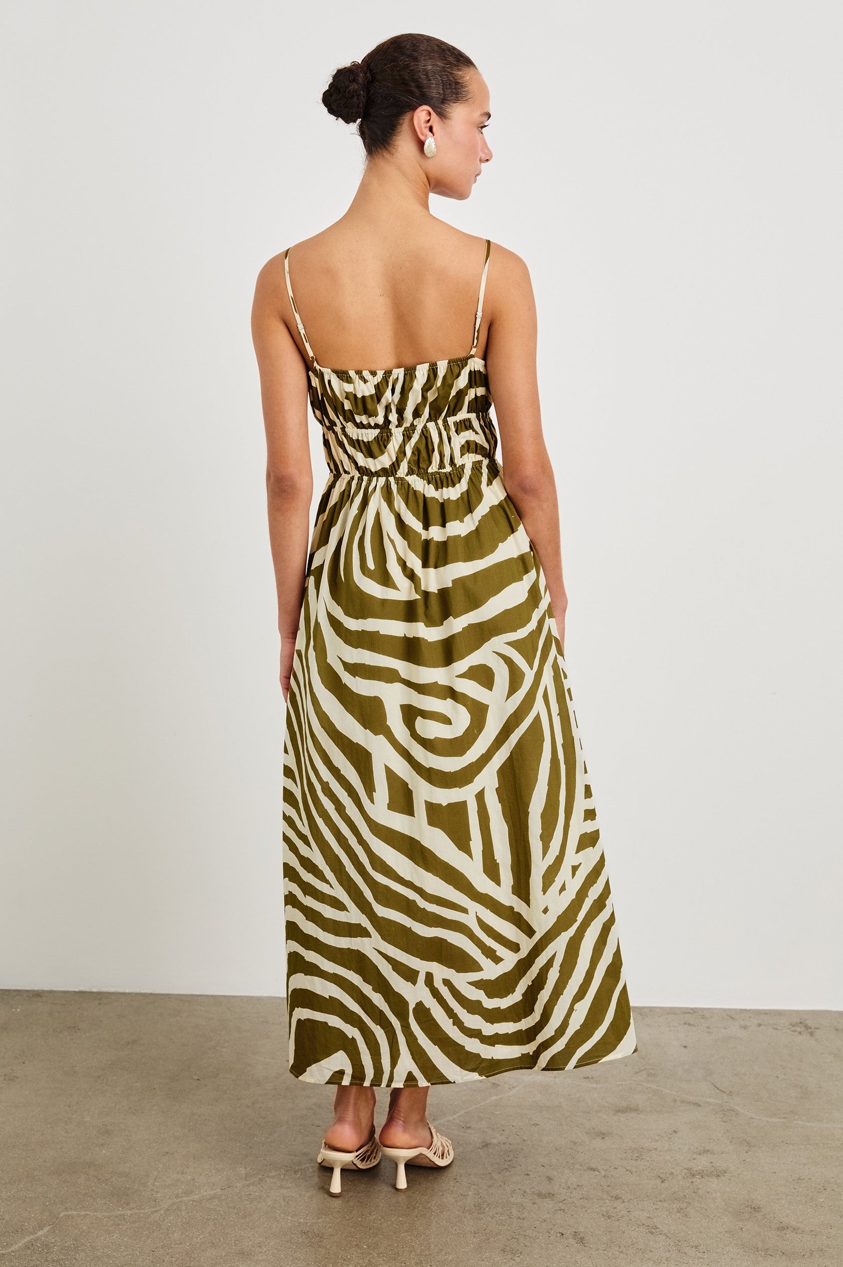 Fatima full length dress with hand painted abstract design, smocked waist, and spaghetti straps in Selva - back view on model with smocking details