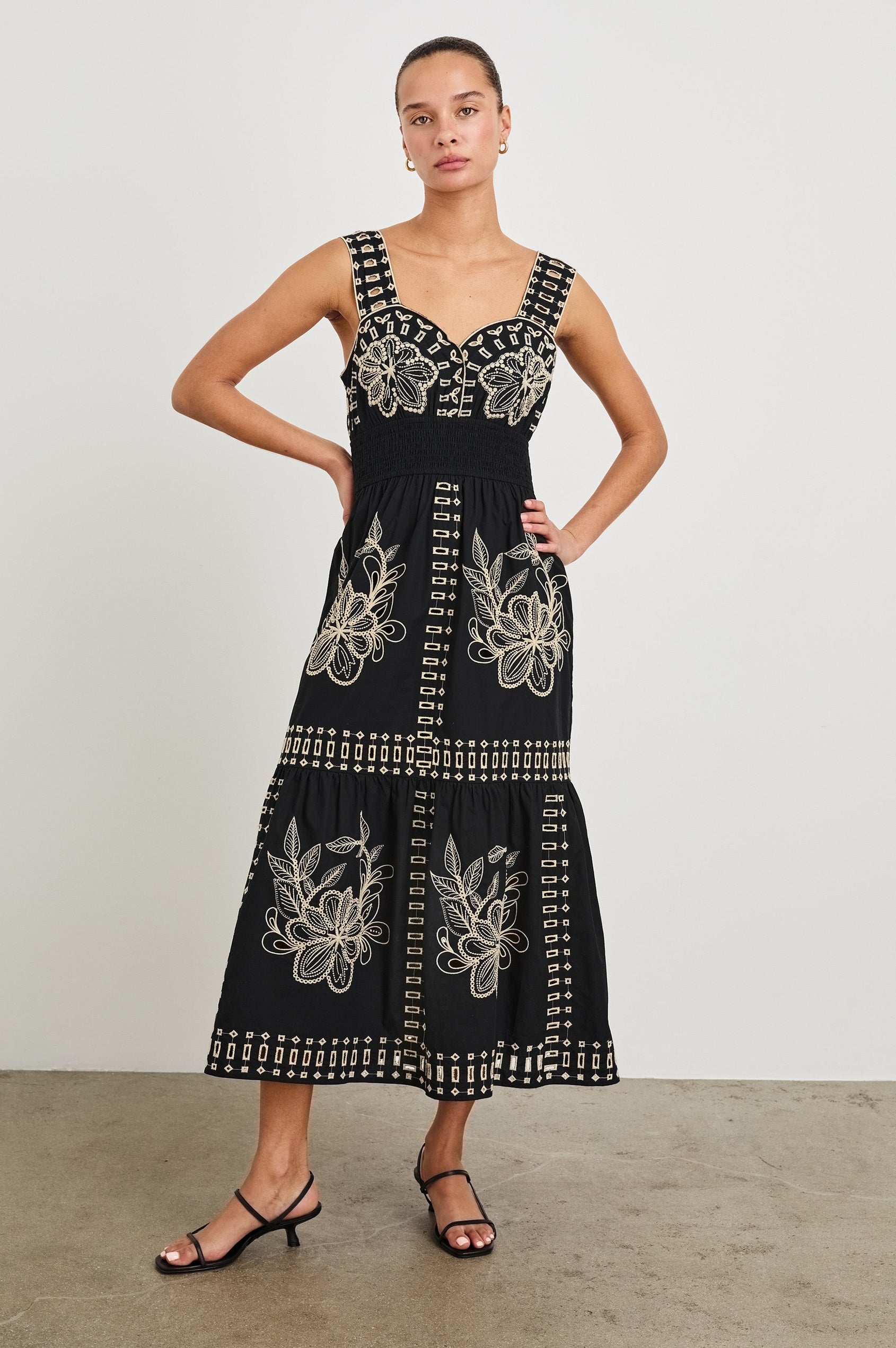 Front view of model wearing our sleeveless, Fawn Midi Dress with Black Tan Embroidery contrast and eyelet details.