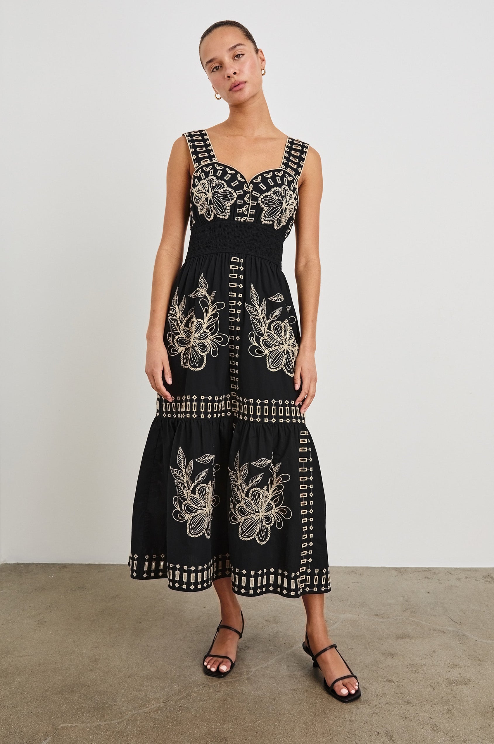 Front view of model wearing our sleeveless, Fawn Midi Dress with Black Tan Embroidery contrast and eyelet details.