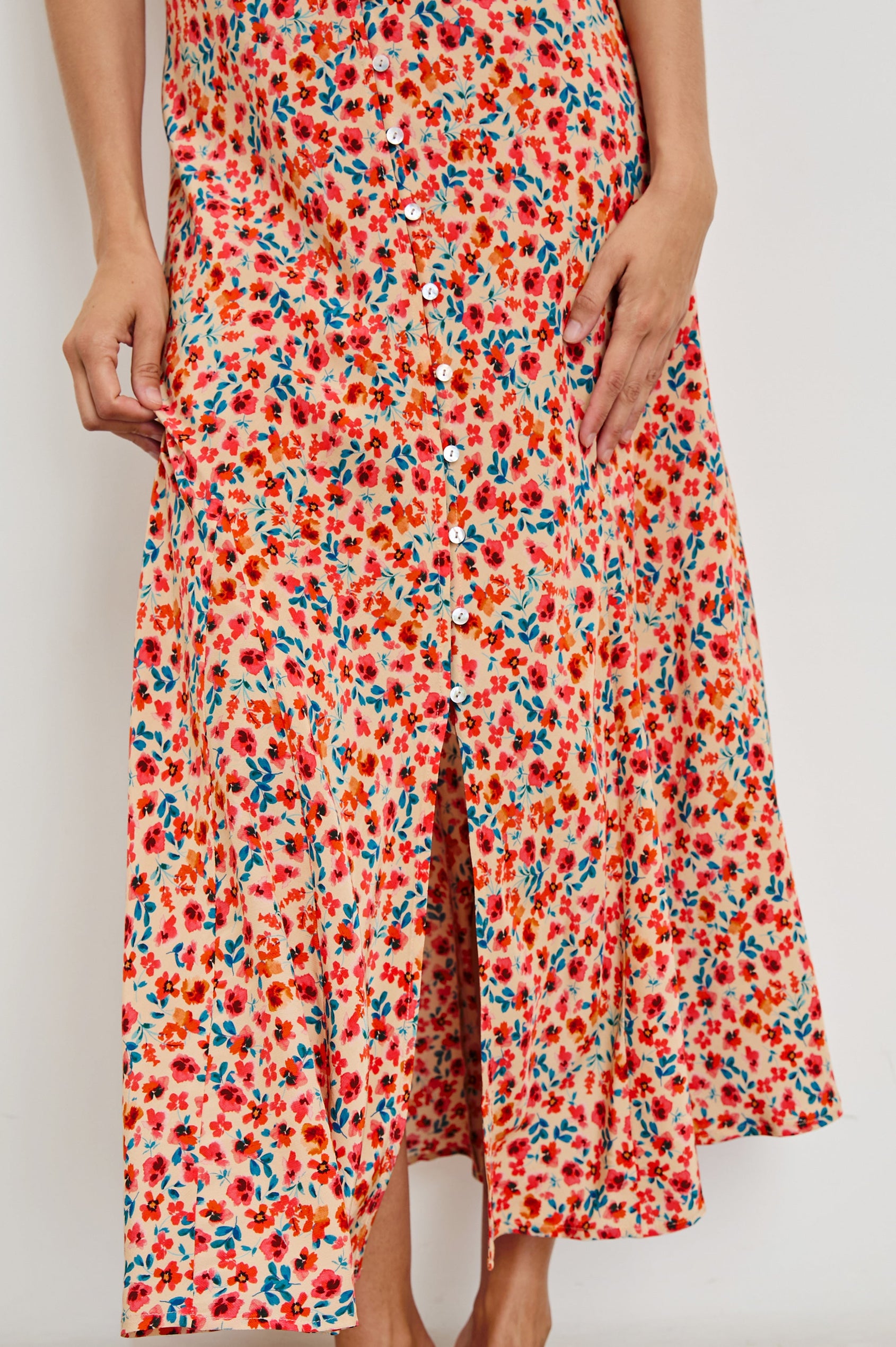 Florian Midi Dress with a V-Neckline, Spaghetti Straps, and Buttons down the front in Red Posy Colorway, Red, Blue and Orange on Tan - Front View Featured on model