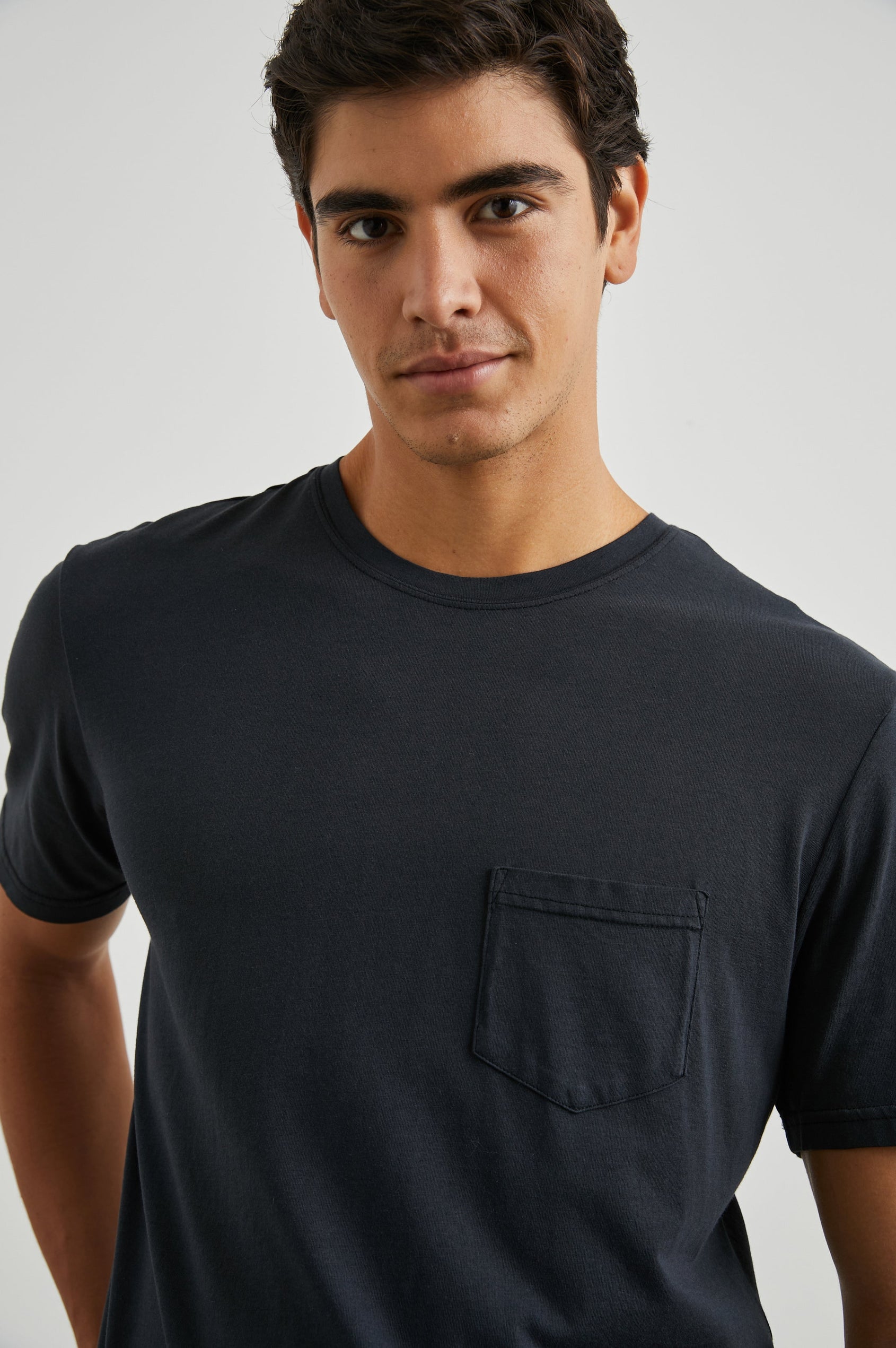 Johnny Short Sleeve T-Shirt with a Crew Neck, Chest Patch Pocket and Small Slits at the Side Hems in Carbon Colorway - Front View Featured on Model