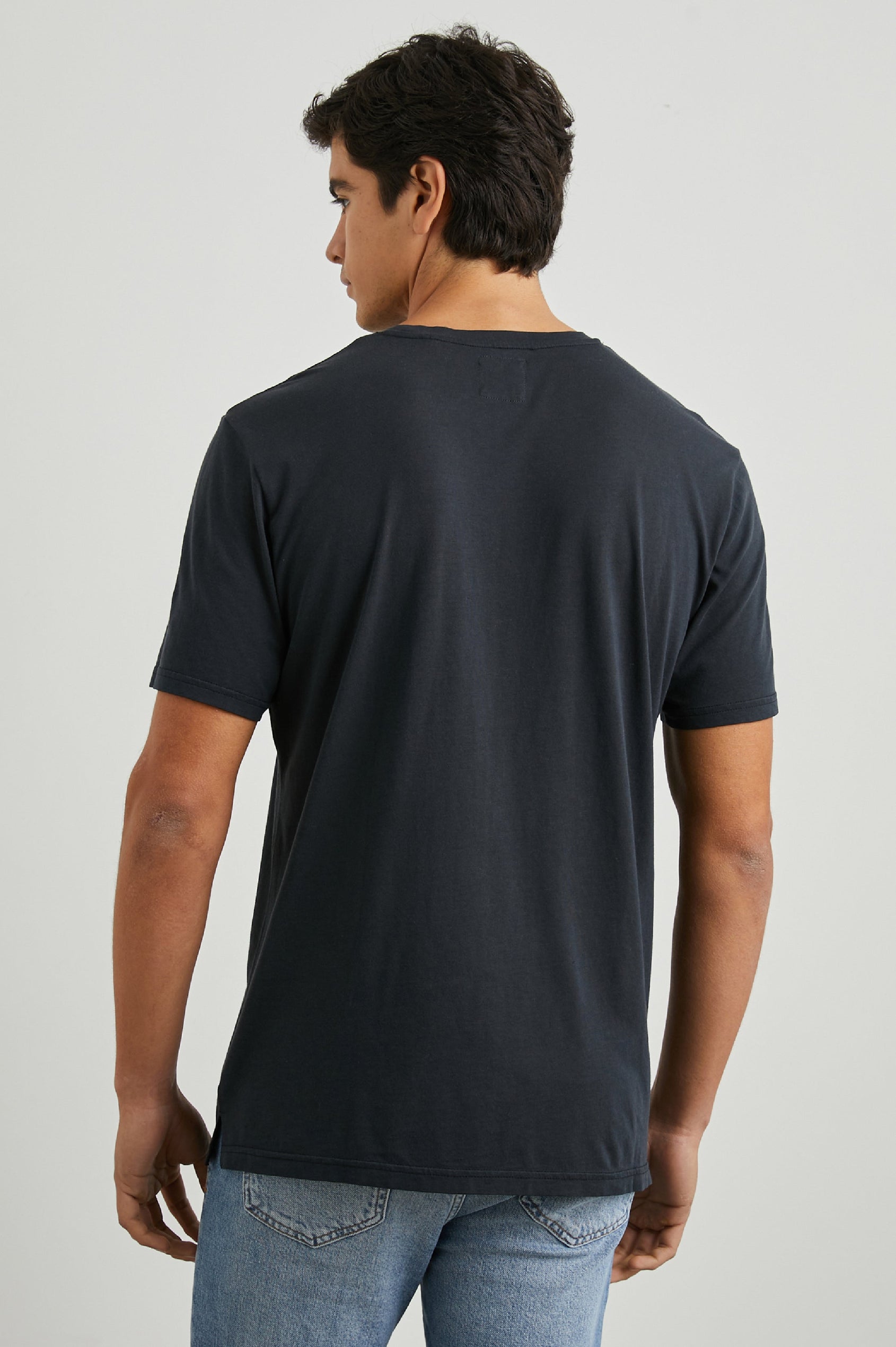 Johnny Short Sleeve T-Shirt with a Crew Neck, Chest Patch Pocket and Small Slits at the Side Hems in Carbon Colorway - Back View Featured on Model
