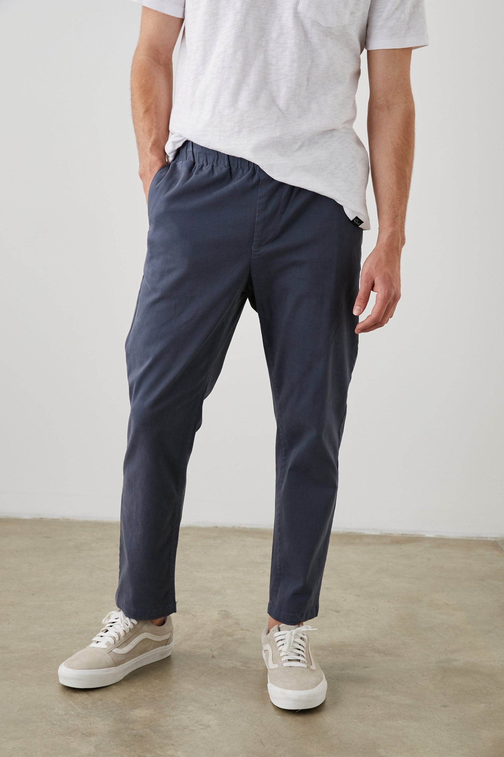 Julian Pants with an Elastic Waist, Two Front Pockets and Two Back Welt Pockets in Faded Blue Colorway - Front View Featured on Model