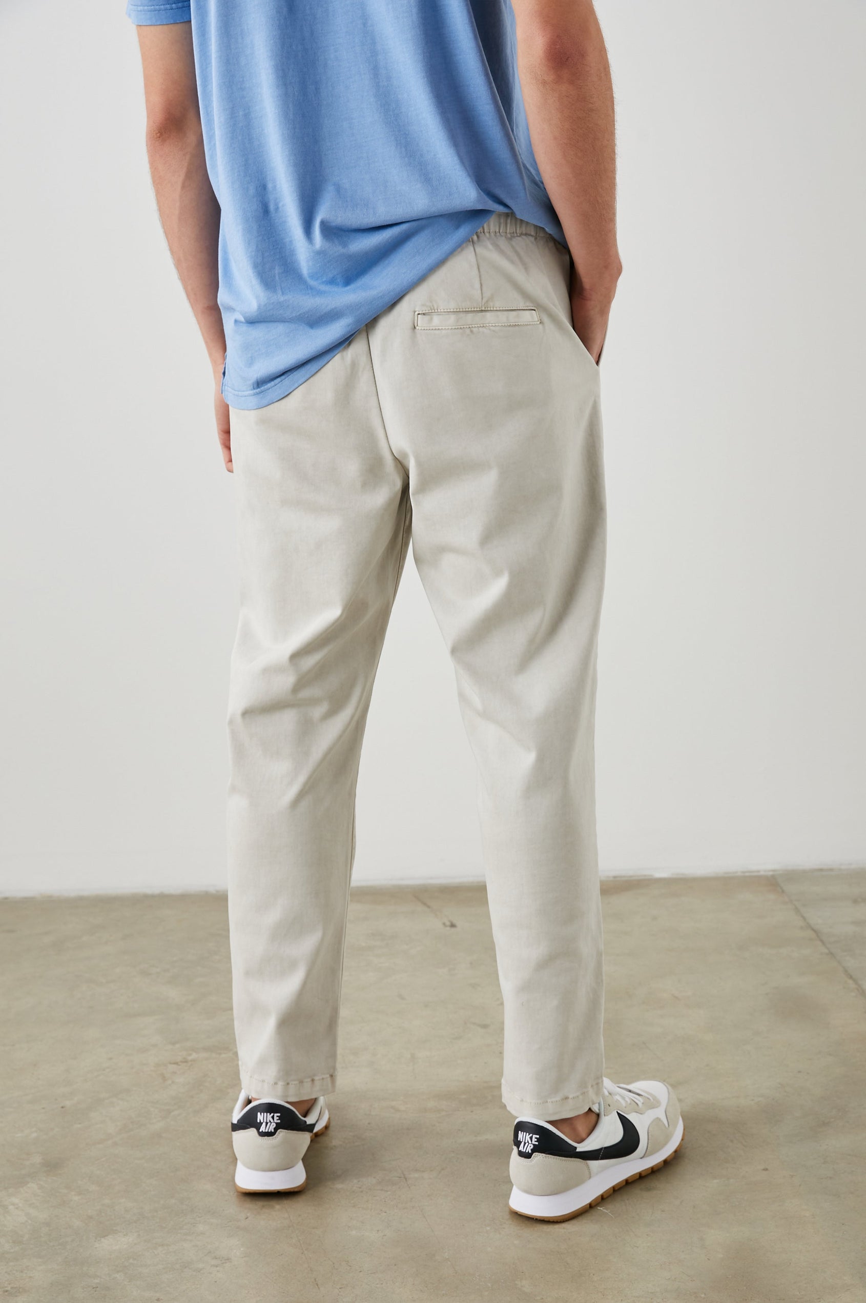 Julian Pants with an Elastic Waist, Two Front Pockets and Two Back Welt Pockets in Natural Colorway - Back View Featured on Model