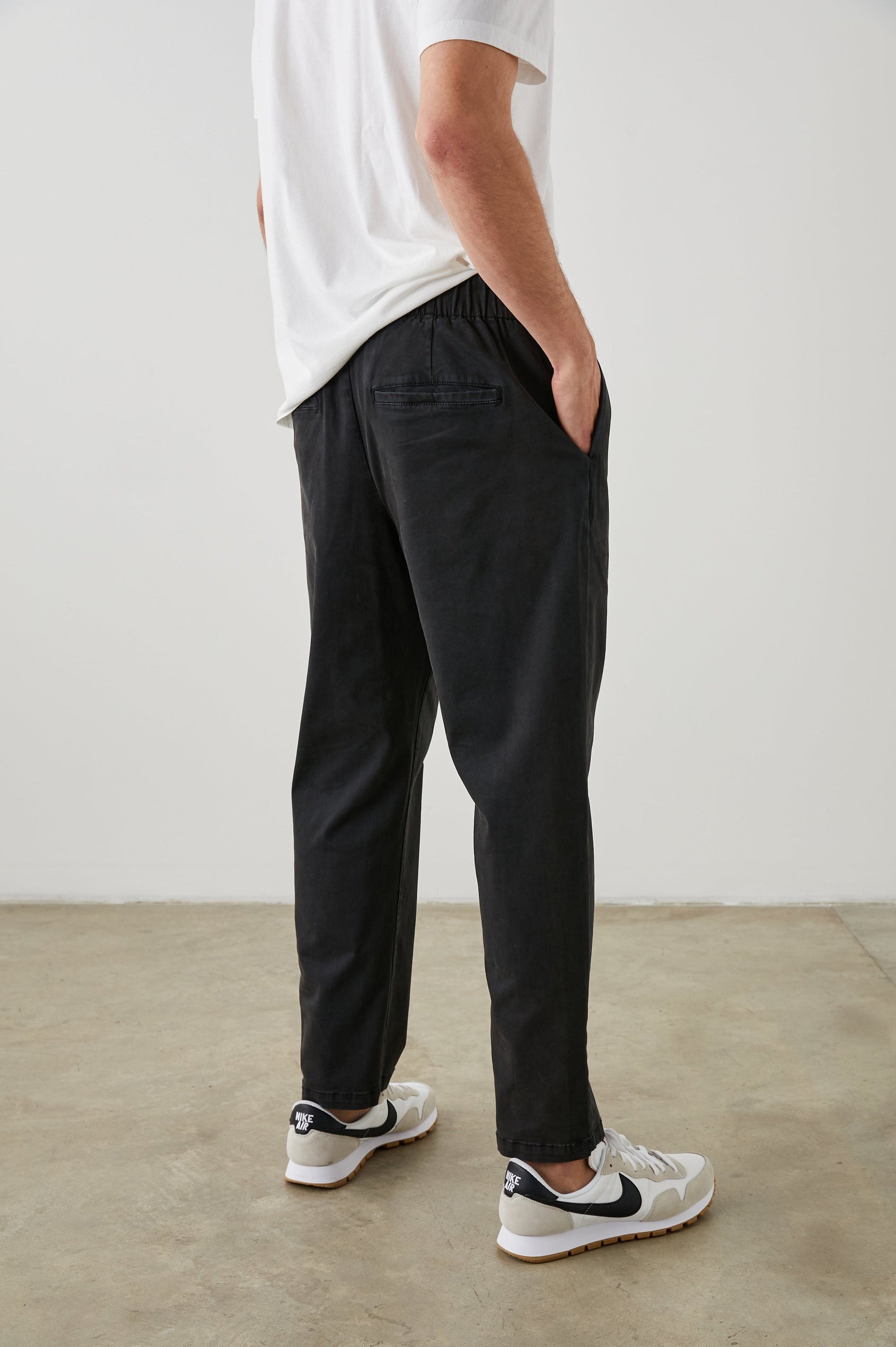 Julian Pants with an Elastic Waist, Two Front Pockets and Two Back Welt Pockets in Washed Black Colorway - Back View Featured on Model