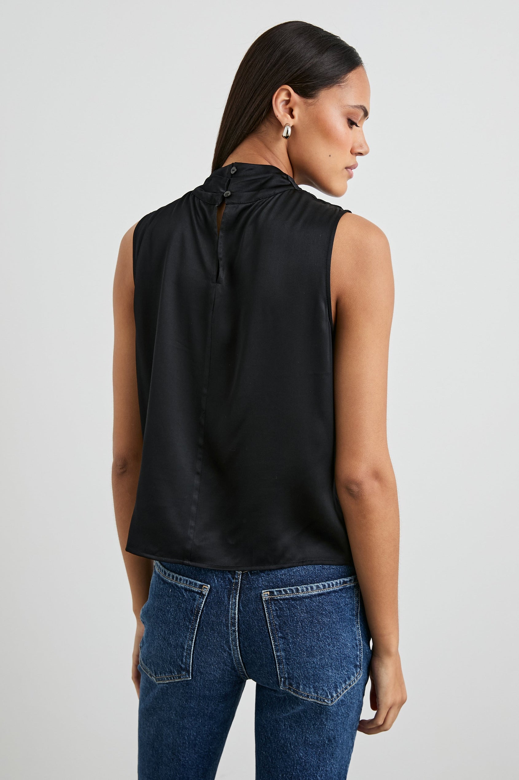 Kaleen Sleeveless Top with Mock Neck with Buttons and Keyhole on the Back and Draped Fabric on the Upper Chest in Ivory Colorway- Back View Featured on Model