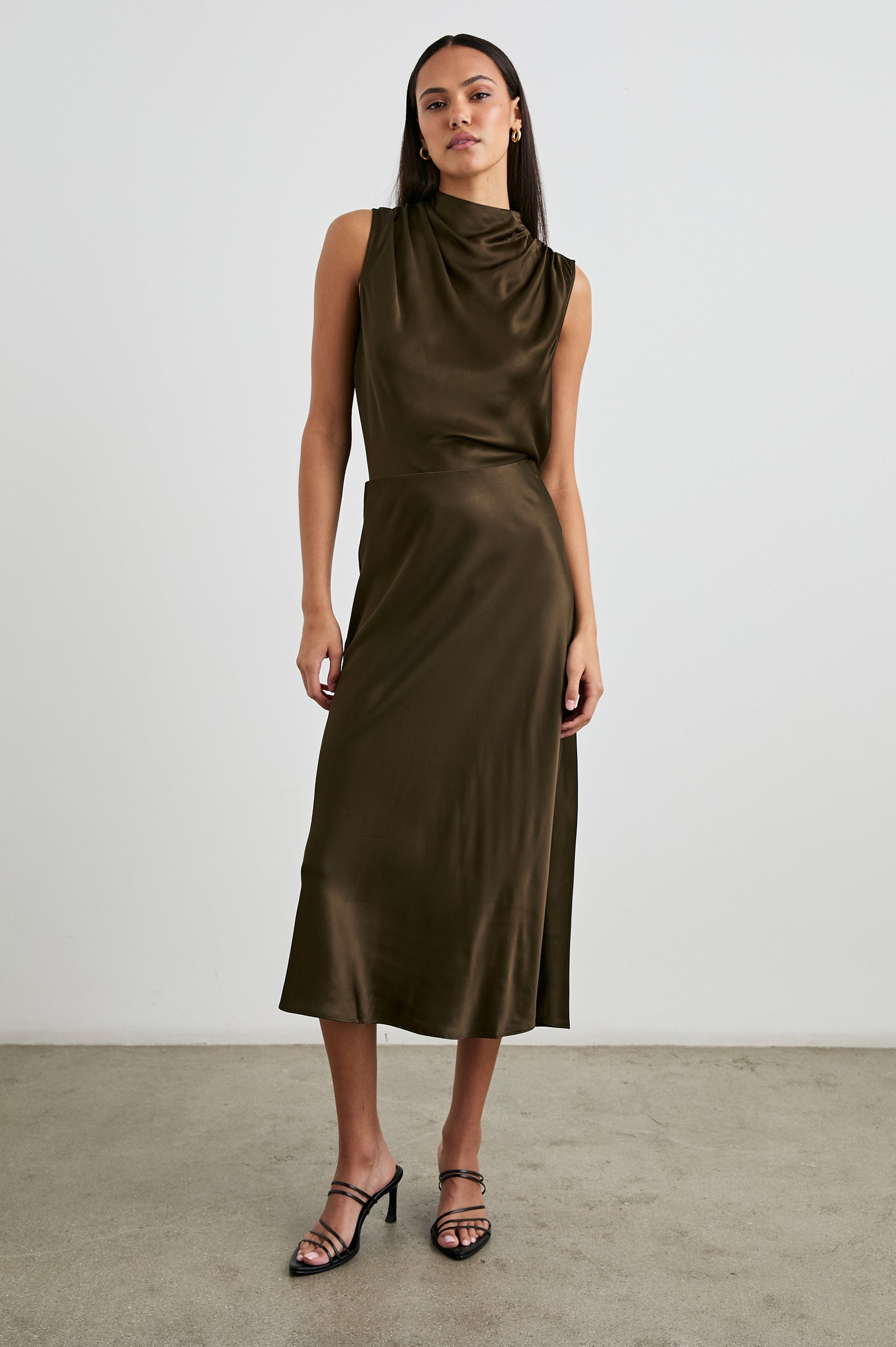 Kaleen Sleeveless Top with Mock Neck with Buttons and Keyhole on the Back and Draped Fabric on the Upper Chest in Dark Moss Colorway- Front Tucked Full Body View Featured on Model