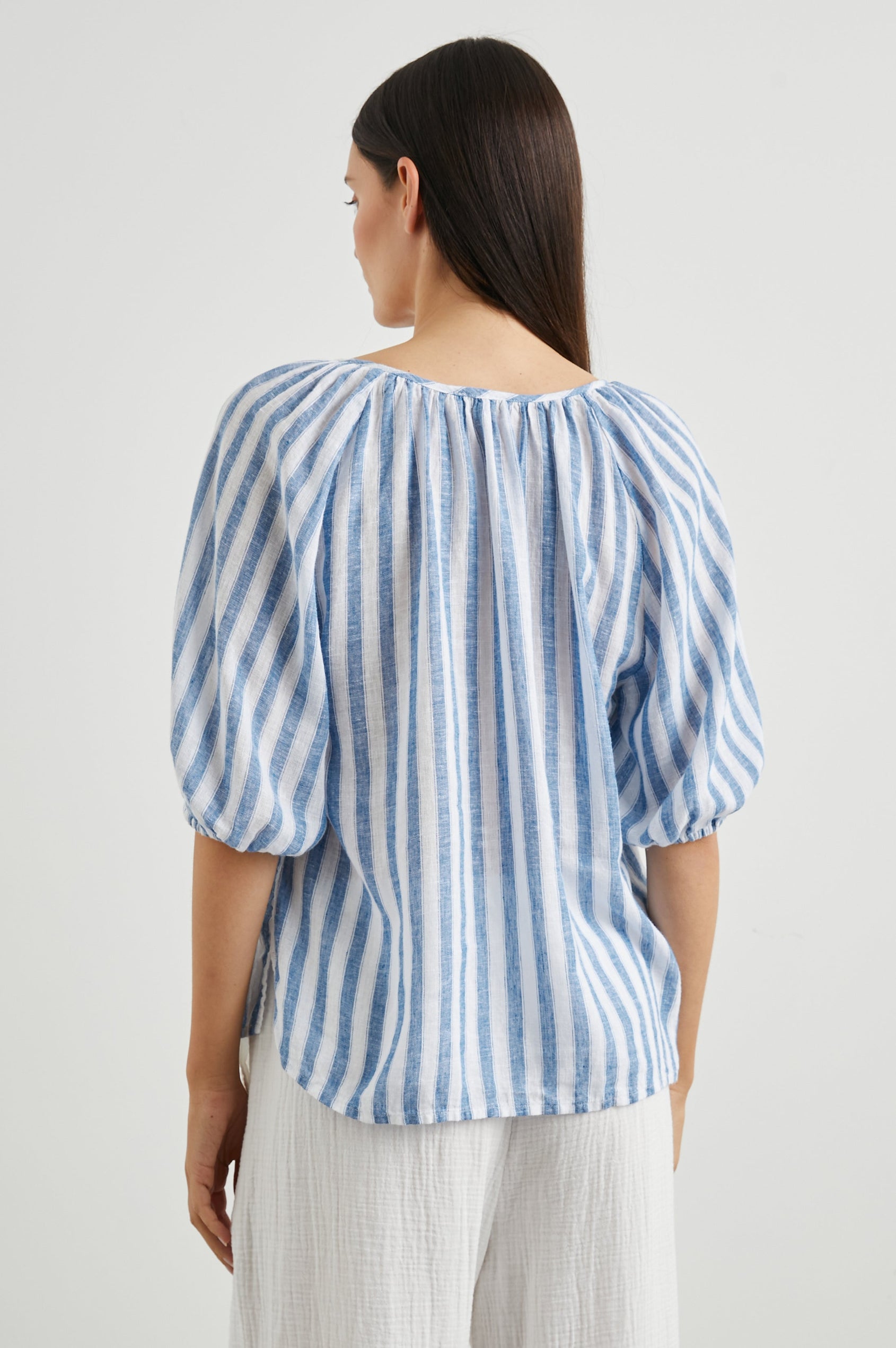 Kristie Top with Elbow Length Sleeves with Elasticized Cuffs and a Deep V Neck with a Tie in Casablanca Stripe Colorway, Blue and White Vertical Stripes - Back View Featured on Model
