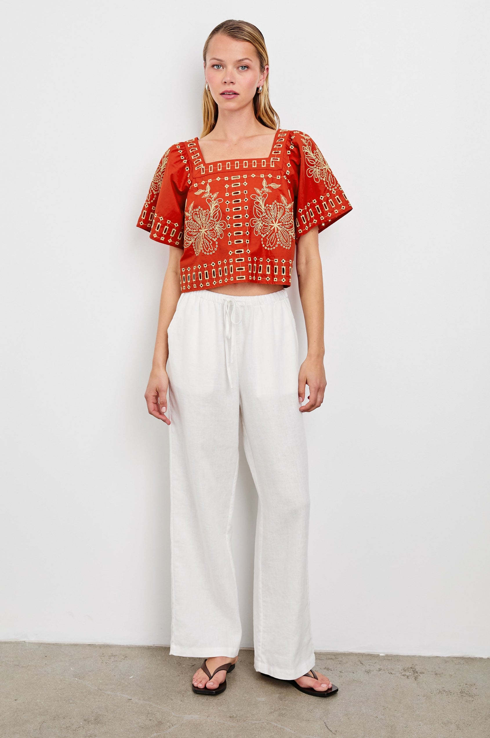 Laine airy cotton poplin top with wide short sleeves and a loose fit. Contrast eyelet embroidery in color Terracotta - front view on model
