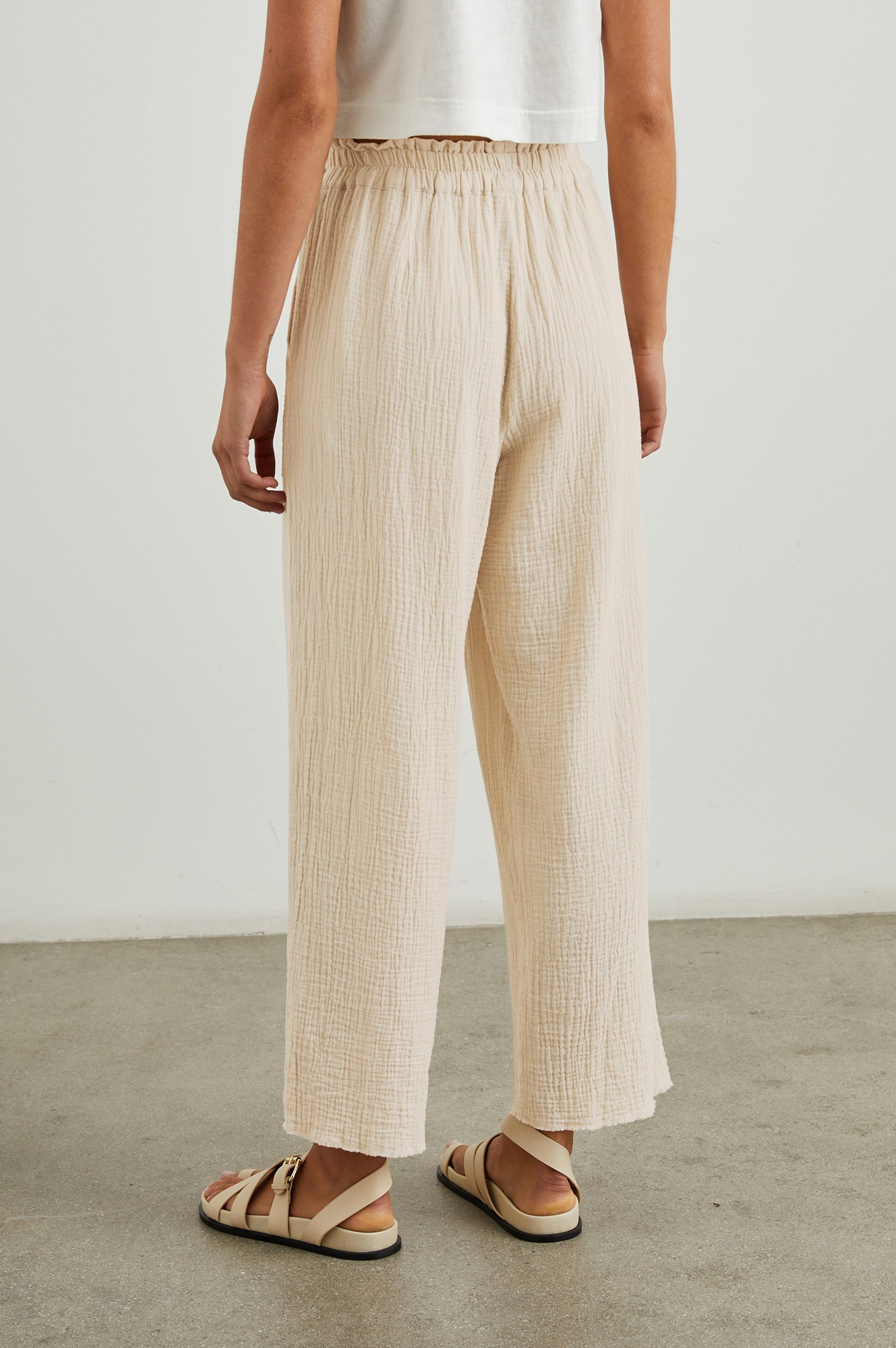 Leon Crop Pant with a Smocked Waistband and Two Front Seam Pockets in Flax Colorway - Back View Featured on Model