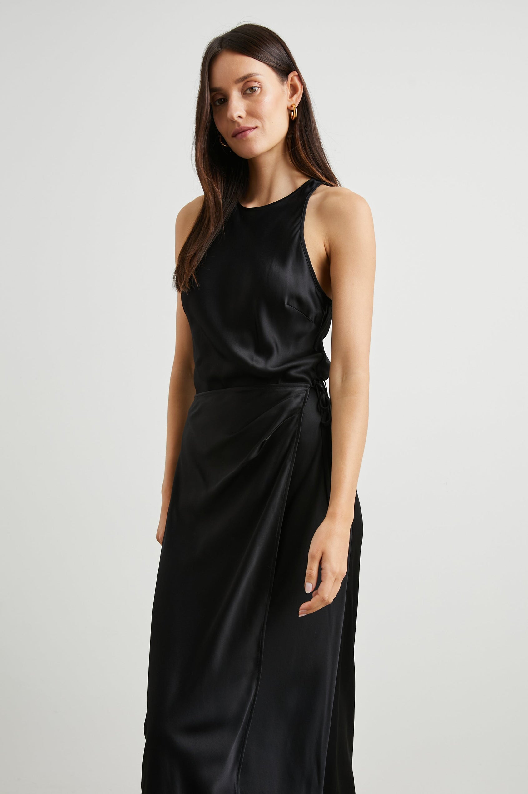 Navi Sleeveless Midi Dress with a Halter Neckline with a Back Tie Keyhole, and a Wrap Skirt with a Side Tie Closure in Black Colorway - Front Full Body View Featured on Model