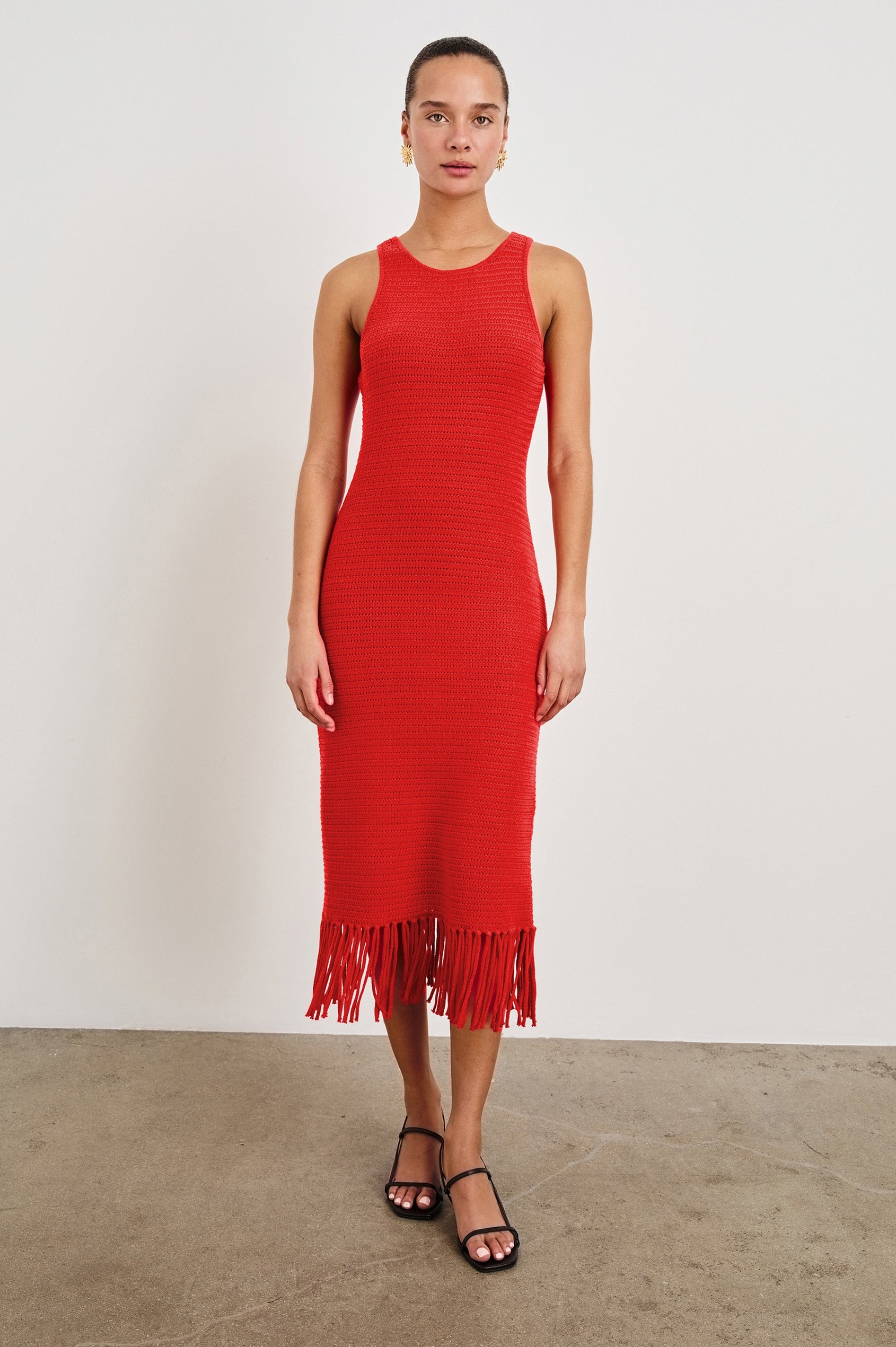 Front view of female model wearing our sleeveless, Nia Midi Dress in color Cherry, featuring crochet structure and fringe details at the hem.