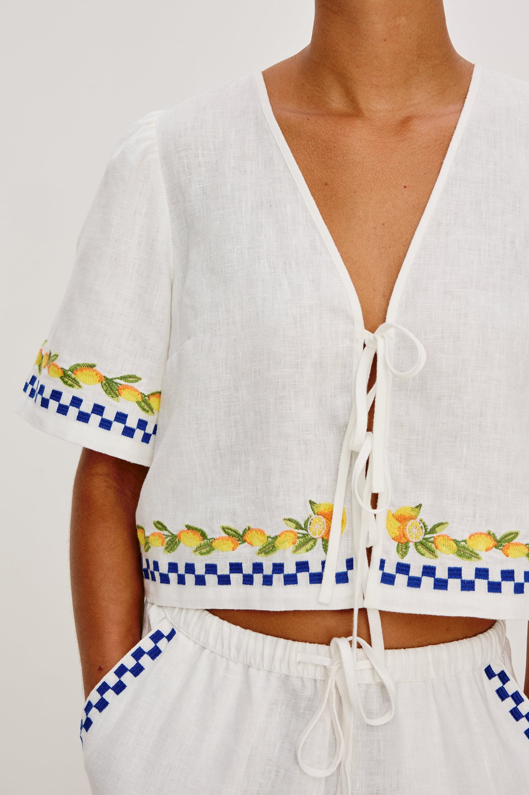 Pari linen top in Sorrento Embroidery colorway. Featuring front tie closures and Italian inspired embroidery - close up of details on model