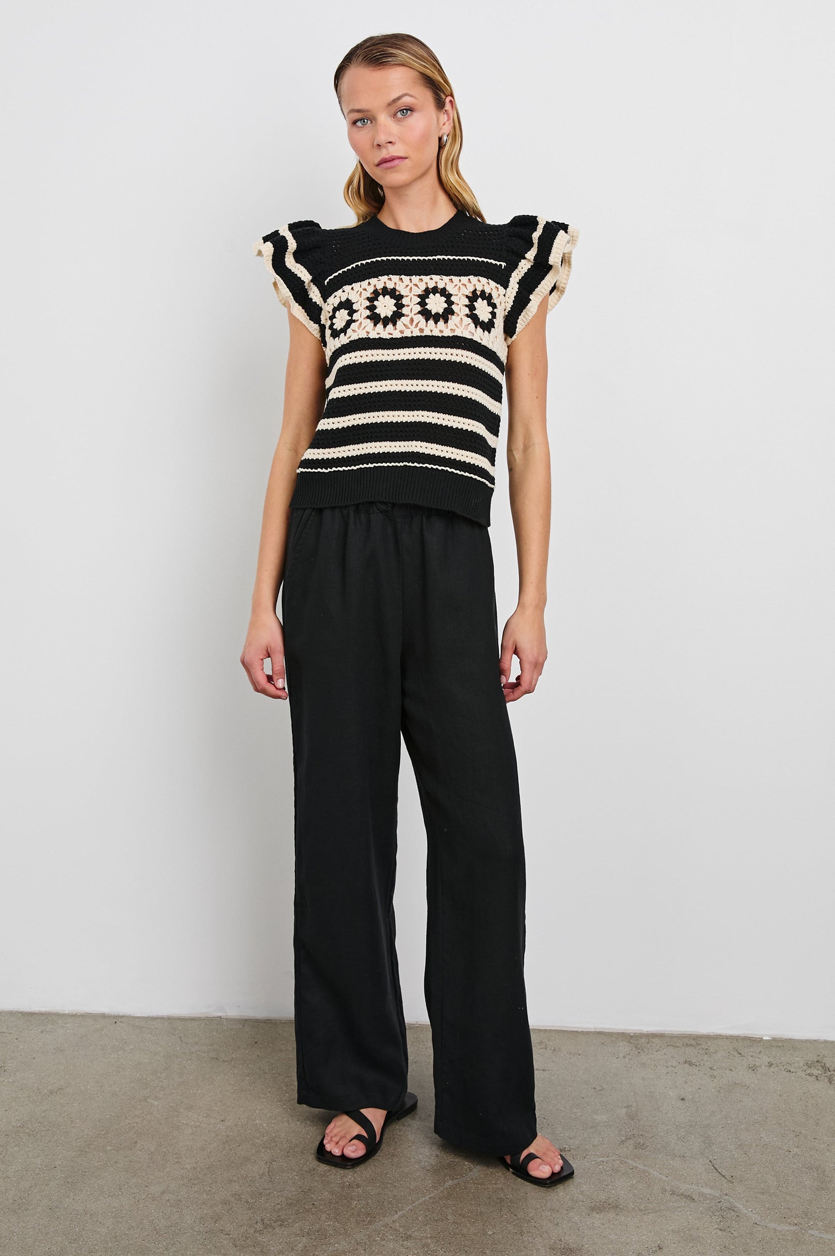 Penelope Crochet Top with Flutter Sleeves and Ribbed Hem in Black Ivory Stripe Colorway, Horizontal Stripes with Contrasting Knit Flowers Across the Chest - Front Full Body View Featured on Model