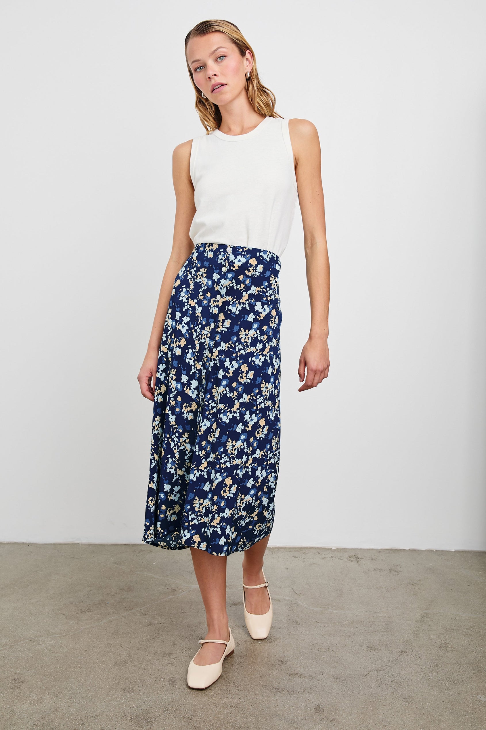 Rosetta Midi Skirt with White Buttons Down the Front in Navy Flora Colorway, with flowers in blues and peaches on navy - Front Full Body View Featured on Model
