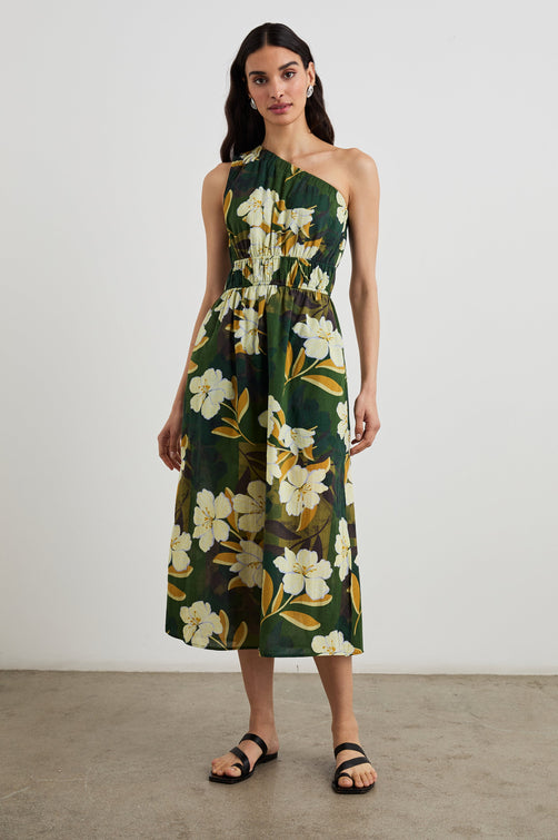 Selani Midi Dress With an Asymmetrical Neckline, Mid-Thigh Slide Slit and Cinched Waistband in Plumerias Colorway, with Ivory and Gold Plumerias on Dark Green - Front Full Body View Featured on Model