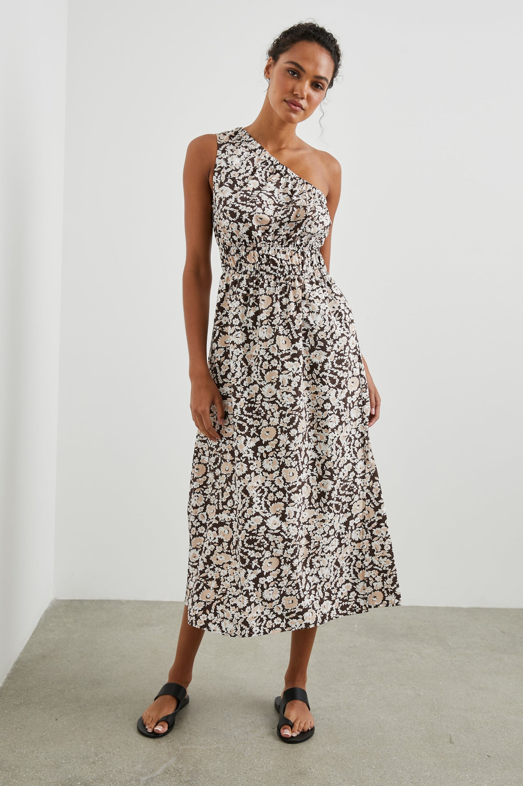 Selani Midi Dress With an Asymmetrical Neckline, Mid-Thigh Slide Slit and Cinched Waistband in Russet Floral Colorway, with white and tan flowers on russet - Front Full Body View Featured on Model