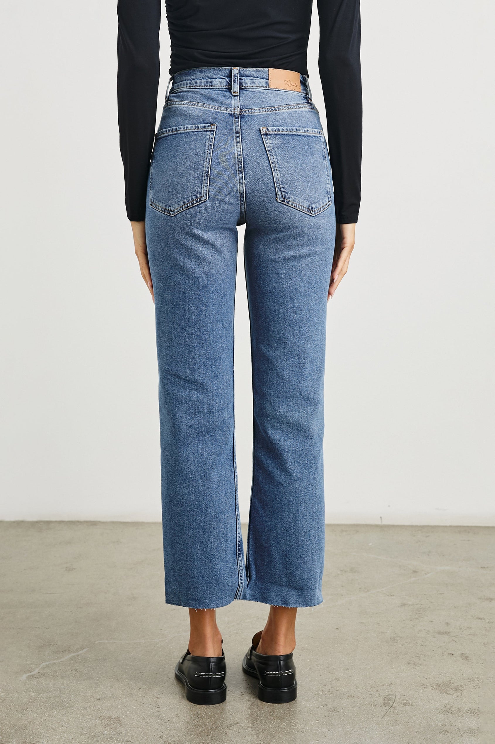 Topanga Crop Straight Jeans with an Asymmetrical Crop, Belt Loops, Two Front Pockets plus a Coin Pocket and Two Back Patch Pockets in Pure Indigo Colorway - Back View Featured on Model