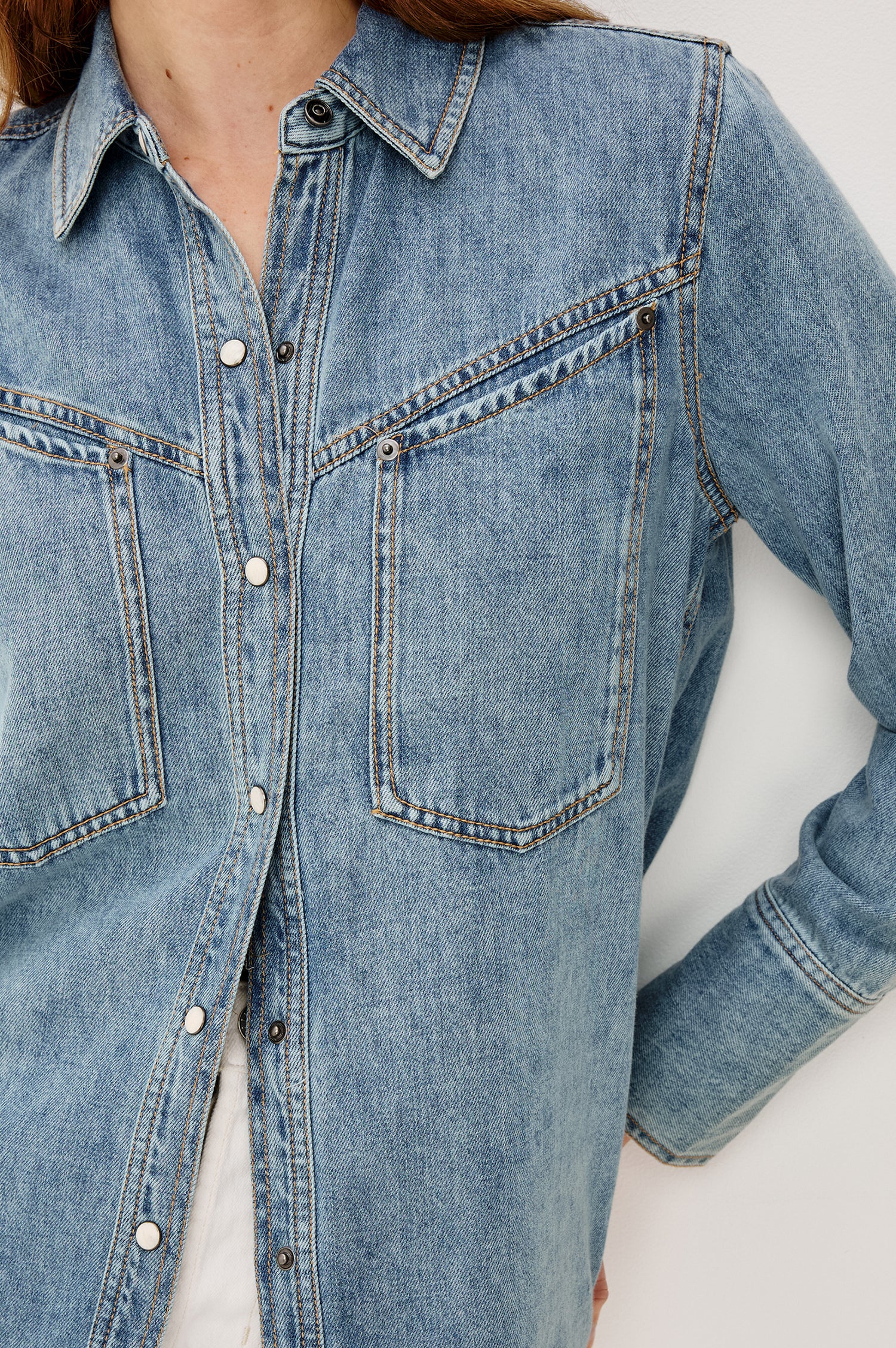 Acton Shirt in Cotton Lyocell Denim With Collar Front Snap Buttons Front and Back Yokes Gunmetal Snap Detailing and Long Sleeves in Wester Blue Colorway - Upper Body Close Up View Featured on Model