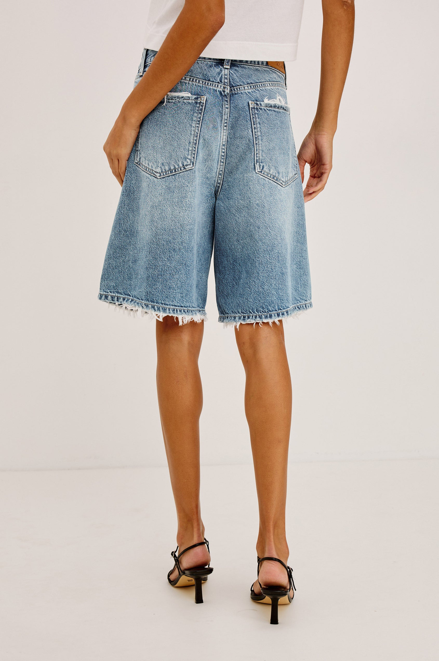 Agoura Short in Rigid Denim With Wide Leg, Relaxed, Low-Slung Fit, Distressed Detailing, Zip Fly, Belt Loops, and 5-Pockets in Authentic Stone Colorway - Full Body Back View Featured on Model