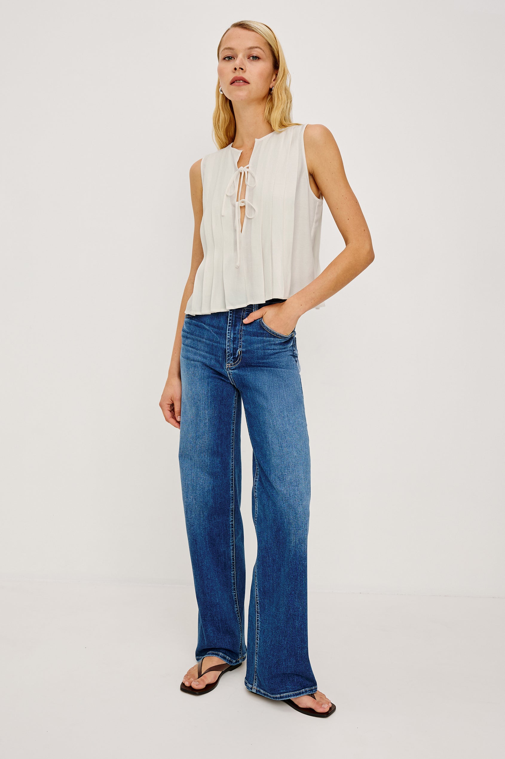 Aja Sleeveless Top in Linen With Plunging V-Neckline and Center-Front Ties and Front Pleats in Ivory Colorway - Full Body Front View Featured on Model