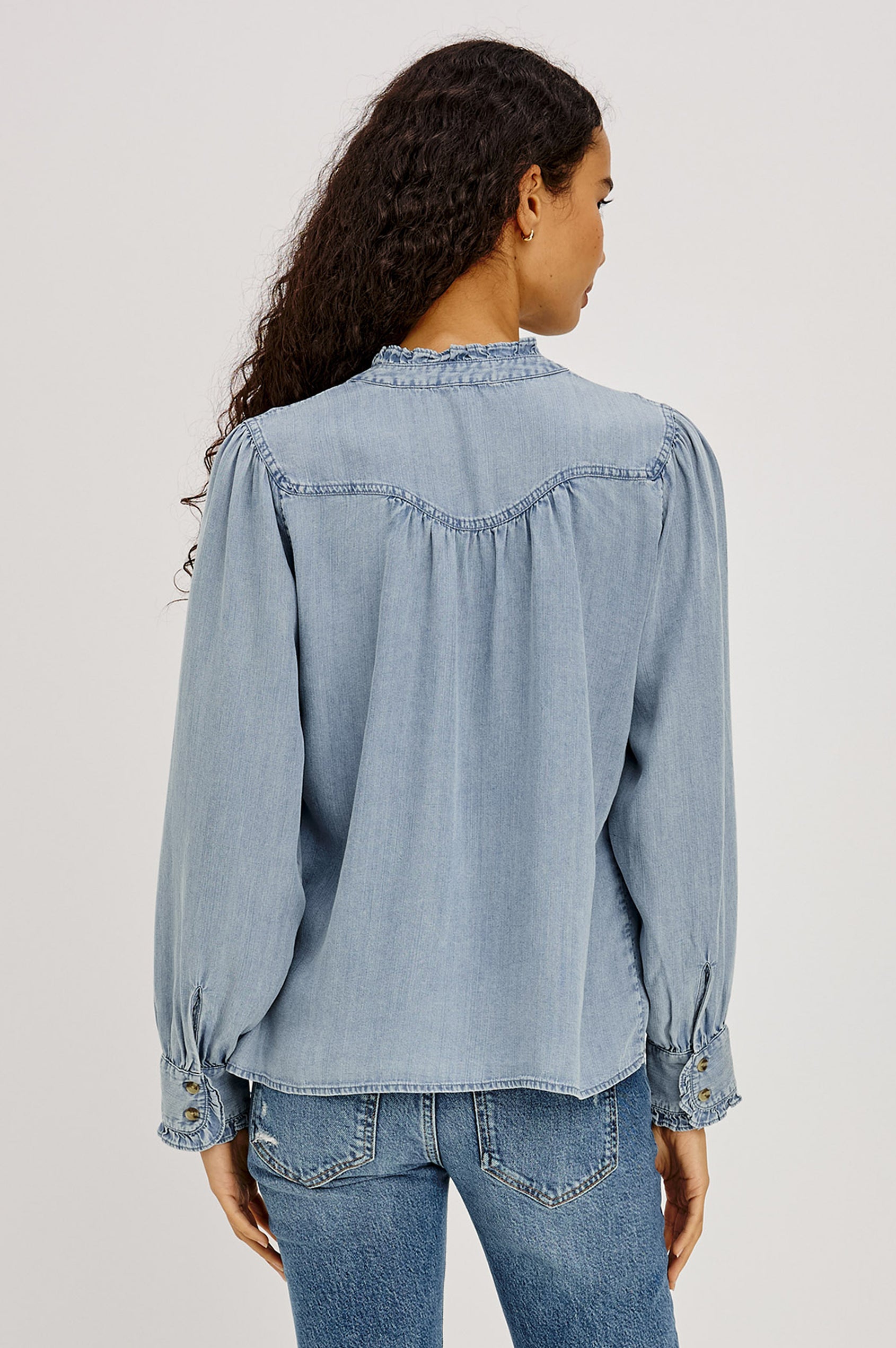 Alanna Shirt in TENCEL™ Denim With Front Buttons, Relaxed Fit, Pointelle Floral Embroidery, Long Sleeves, Curved Yoke, and Ruffle Trim in Medium Cloud Wash Colorway - Upper Body Back View Featured on Model