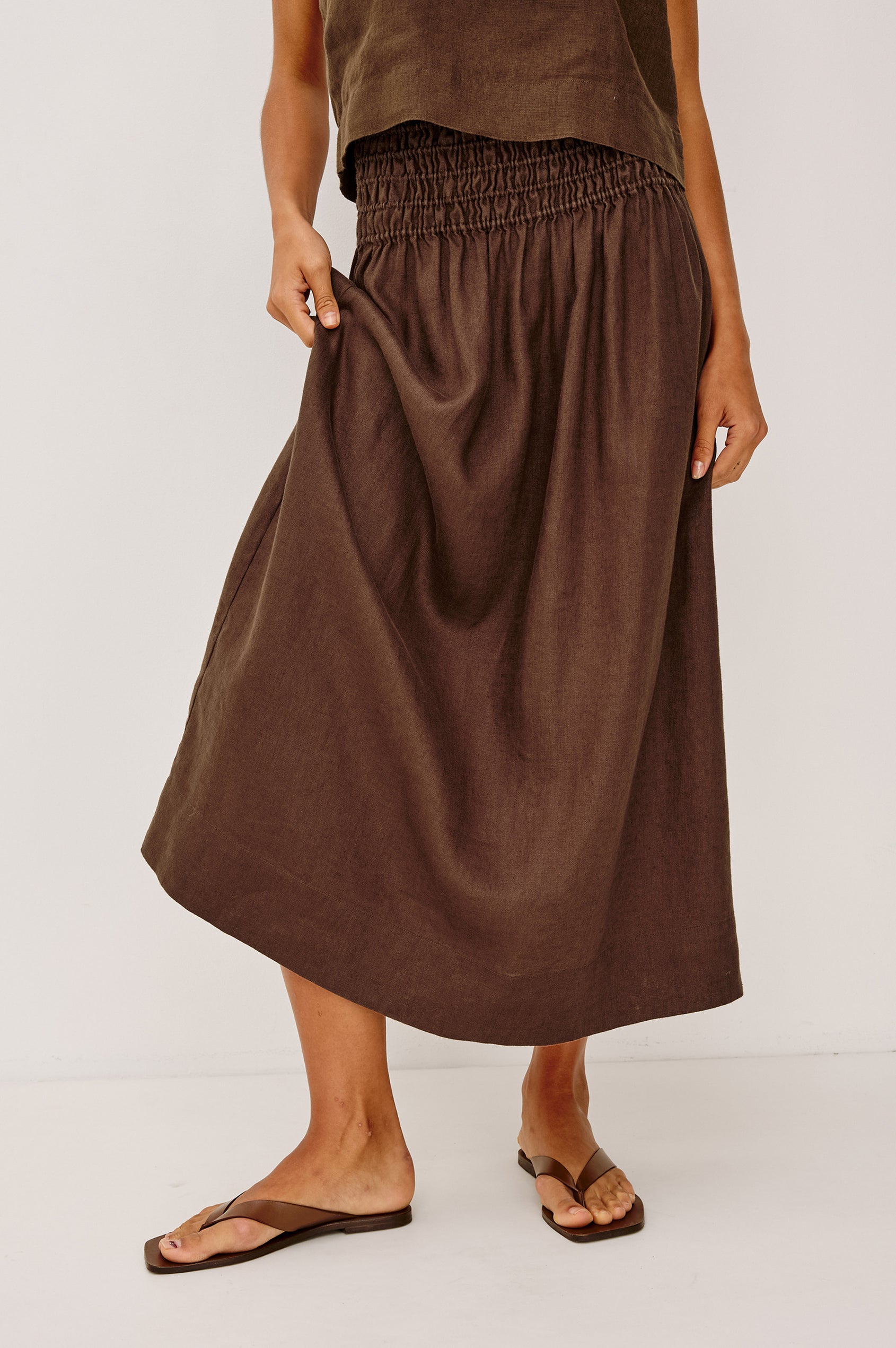 Alessa Midi Skirt in Heavy Linen With Wide Smocked Waistband and A-Line Silhouette in Espresso Colorway - Lower Body Front View Featured on Model