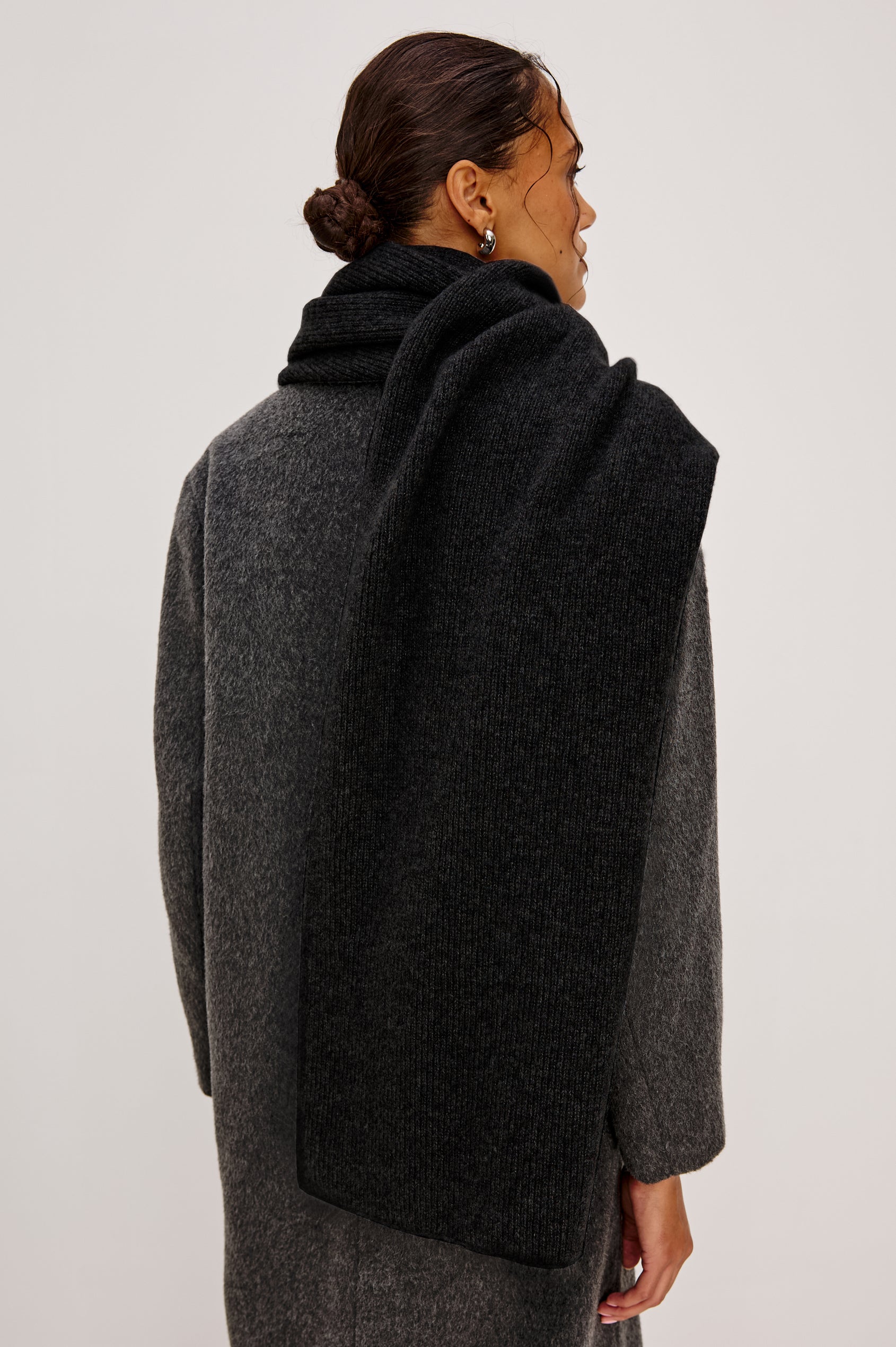 Alps knitted cashmere blend scarf in Black coloraway. Back view featured on model.