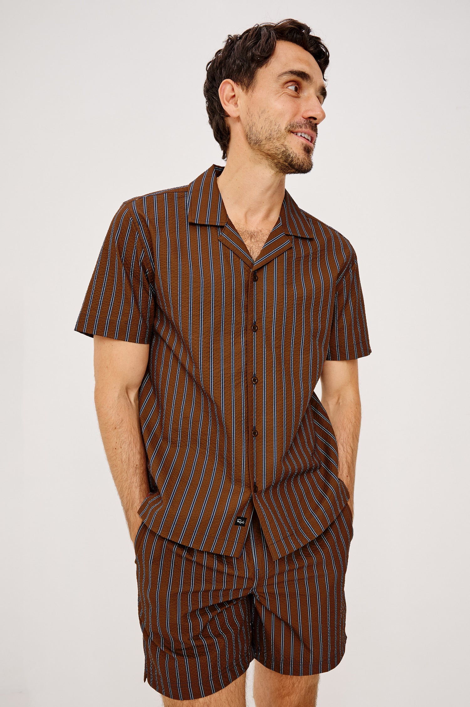 Amalfi Camp Shirt in Lightweight Seersucker With Notched Collar, Front Buttons, Short Sleeves, and Relaxed Fit in Rust Navy Stripe Colorway - Upper Body Front View Featured on Model