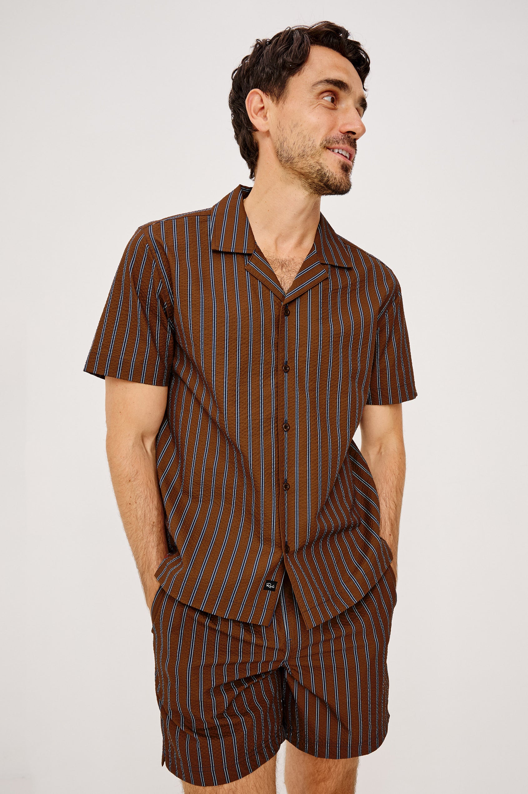 Amalfi Camp Shirt in Lightweight Seersucker With Notched Collar, Front Buttons, Short Sleeves, and Relaxed Fit in Rust Navy Stripe Colorway - Upper Body Front View Featured on Model