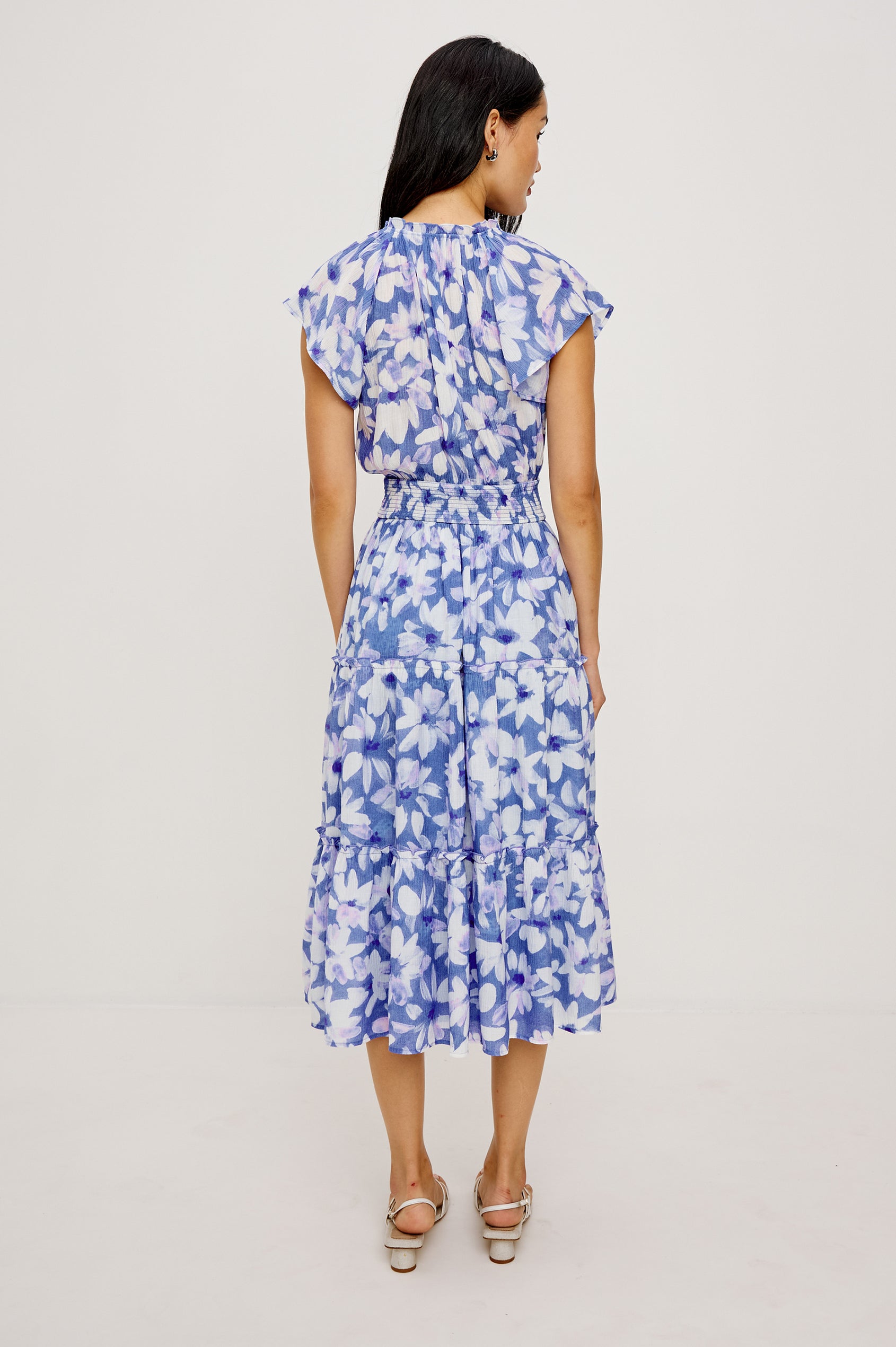 Amellia Midi Dress in Chiffon With Ruffled Split V-Neckline Flutter Sleeves a Smocked Waist and Tiered A-Line Skirt in Blue Ameranth Colorway - Full Body Back View Featured on Model