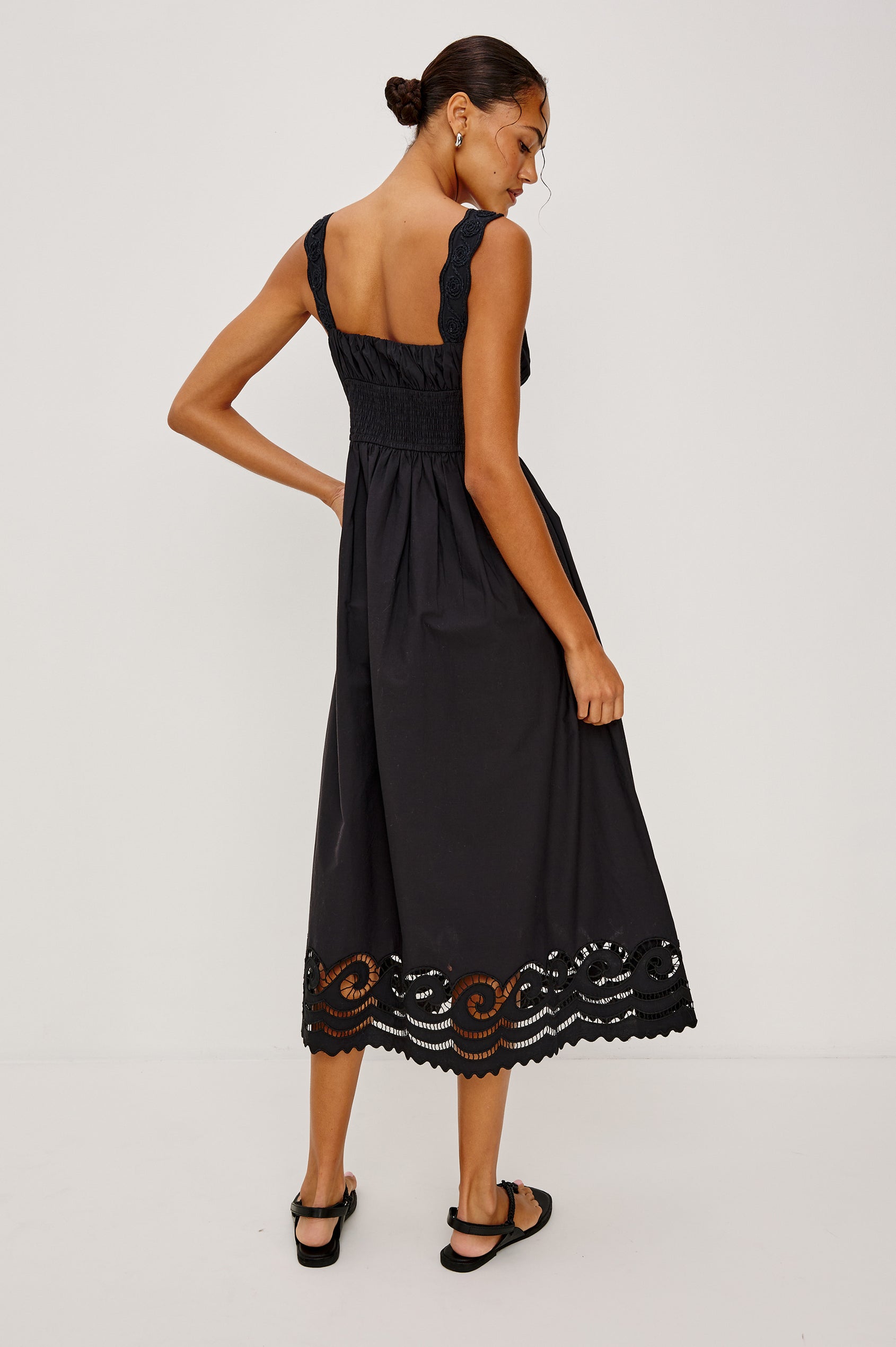 Anadia Maxi Dress in Poplin With Soutached Swirl Shoulder Straps, Ruched Bust, Smocked Empire Waist, and Scalloped Ladder Embroidered Hem in Black Colorway - Full Body Back View Featured on Model