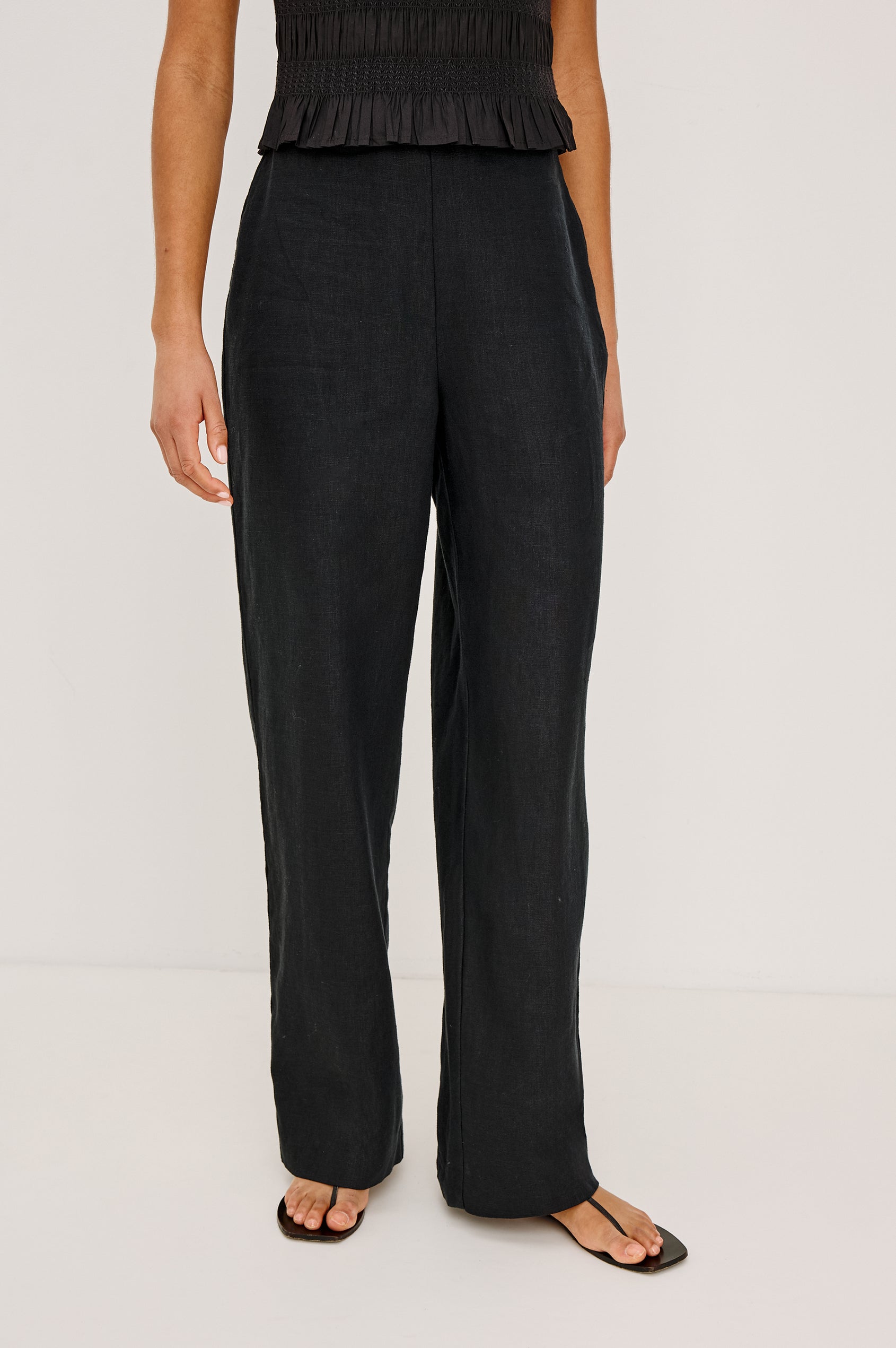 Andrine Pant in Heavy Linen With High-Waisted Fit, Straight Legs, Unlined, Side On-Seam Pockets, Side Zip Closure in Black Colorway - Lower Body Front View Featured on Model