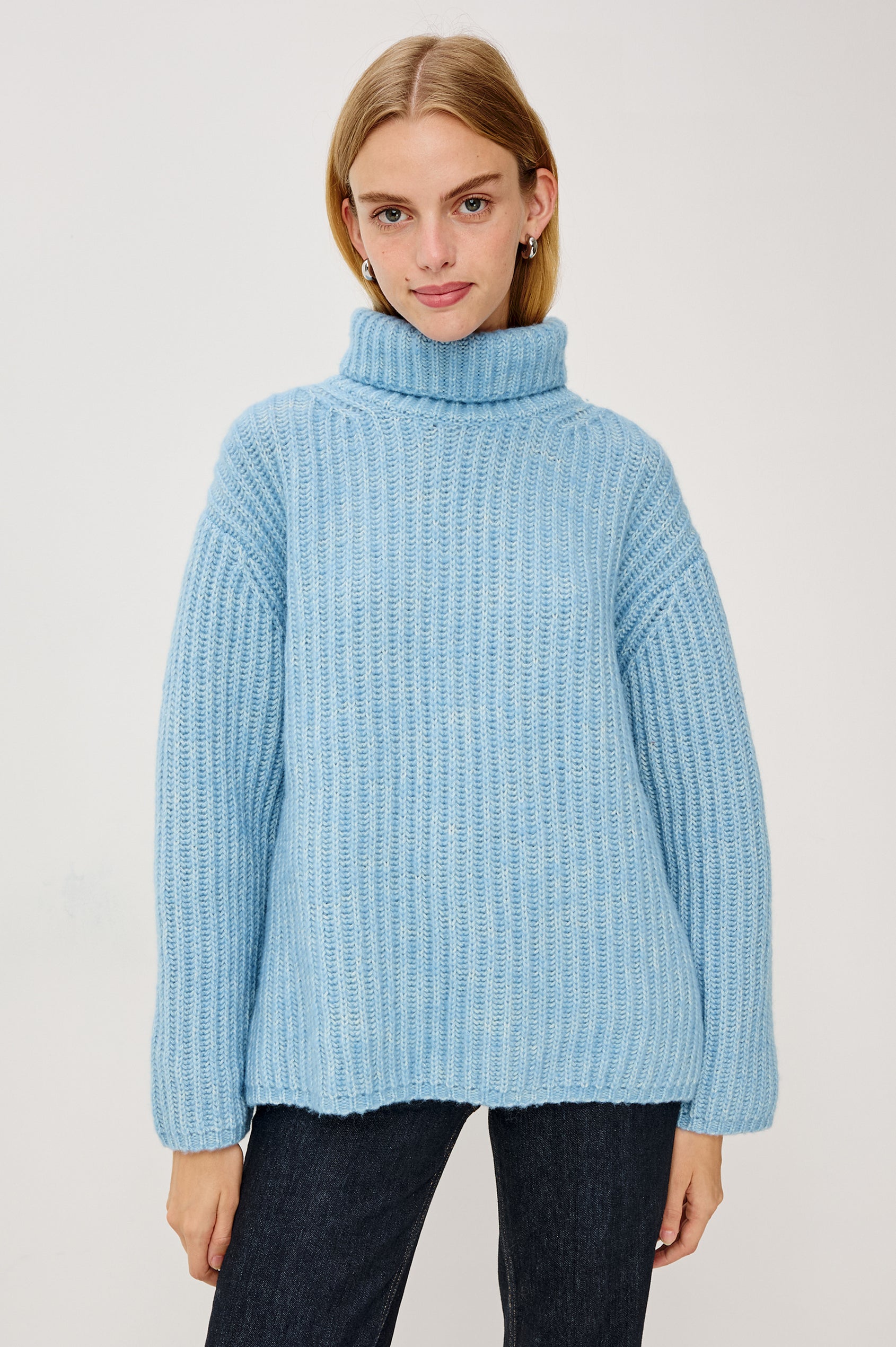 Anja Turtleneck Sweater in Soft Ribbed Knit With Relaxed Fit, High Low Hem, and Long Sleeves in Light Blue Colorway - Upper Body Front View Featured on Model