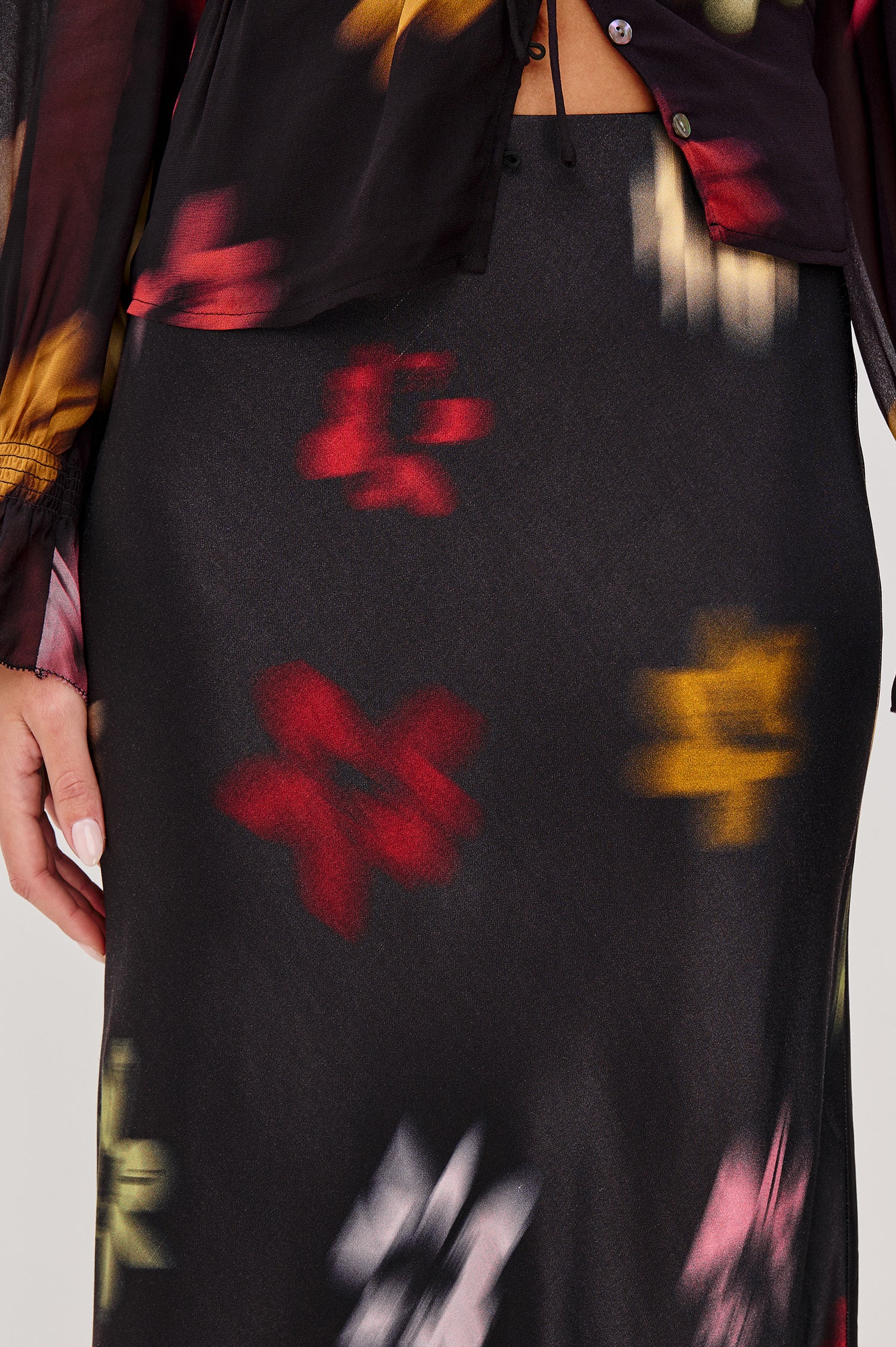 Anya High-waisted Midi Skirt in Onyx Blurred Floral Colorway - Close Up View Featured on Model