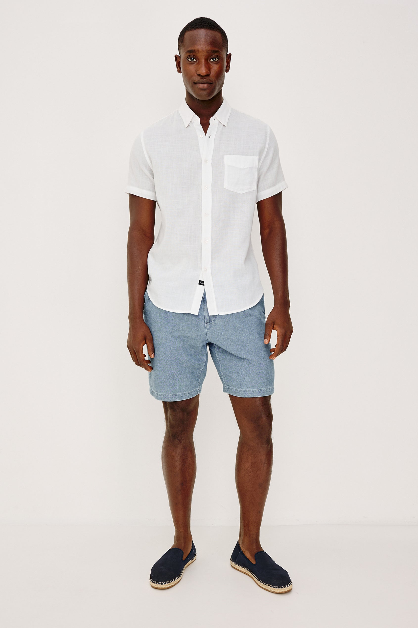 Archer Short in Unlined Cotton Linen With Relaxed Fit, Adjustable Waist Drawstring Ties, Side Pockts, and 8.5-Inch Inseam in Medium Wash Indigo Colorway - Front View Featured on Model