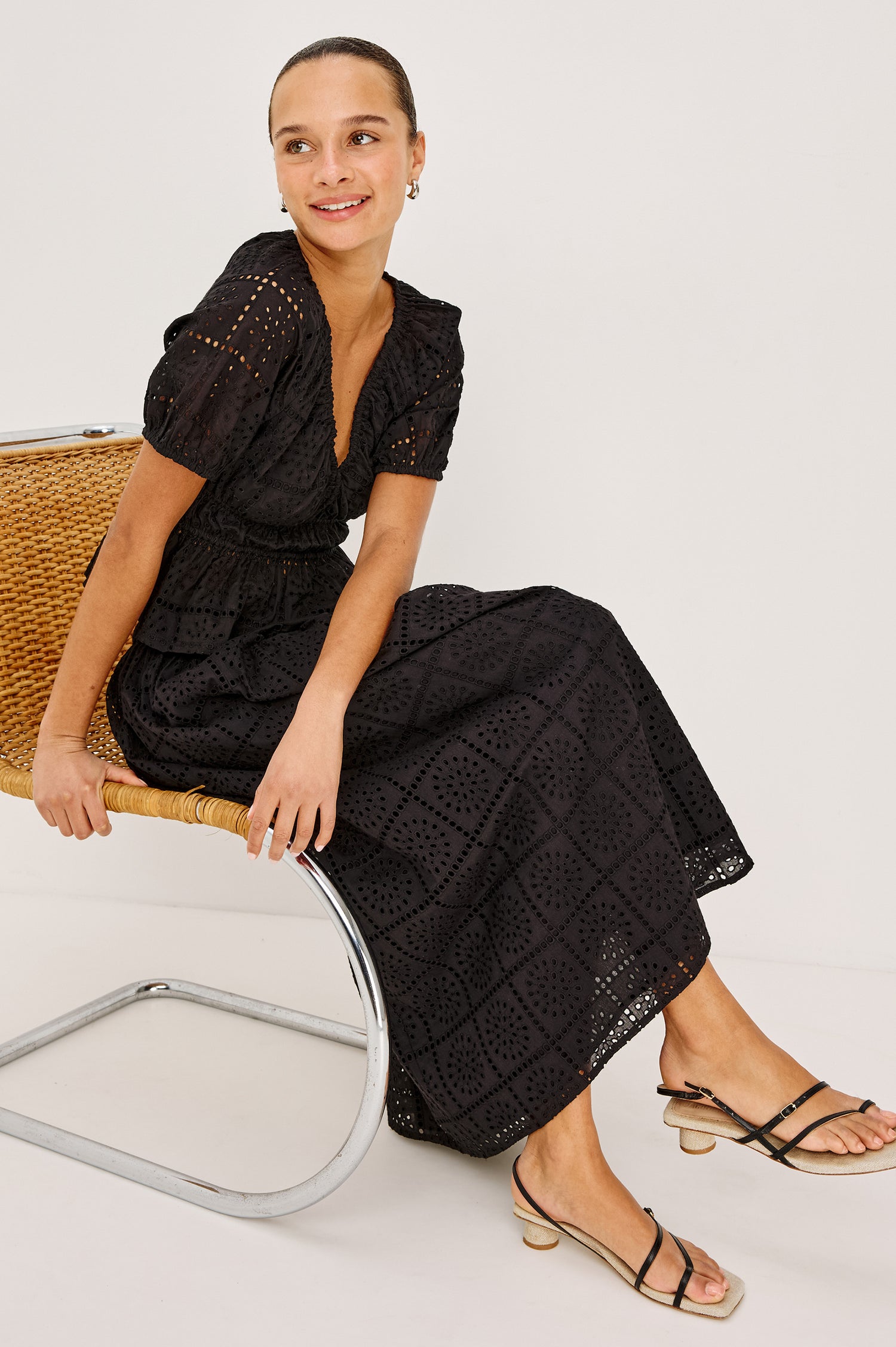Argenta Top in Cotton Voile With Embroidered Pattern, Short Puff Sleeves, Hook-and-Eye Closure, Elastic V-Neckline and Waist, and Peplum Hem in Black Grid Embroidery Colorway - Stylized View Featured on Model