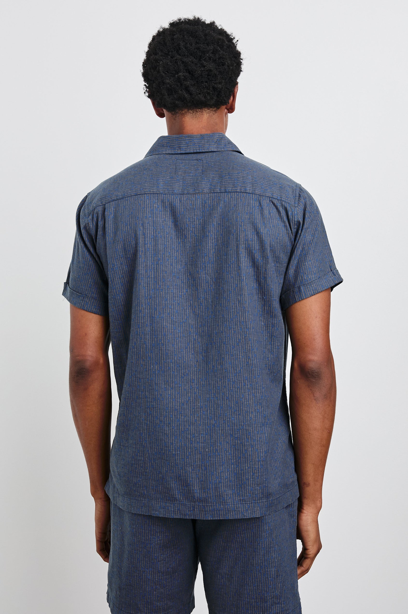 Atlas Short-Sleeve Button Up in Navy Cedar Vertical Colorway, with Thin Vertical Cedar Dashes on Navy - Back View Featured on Model