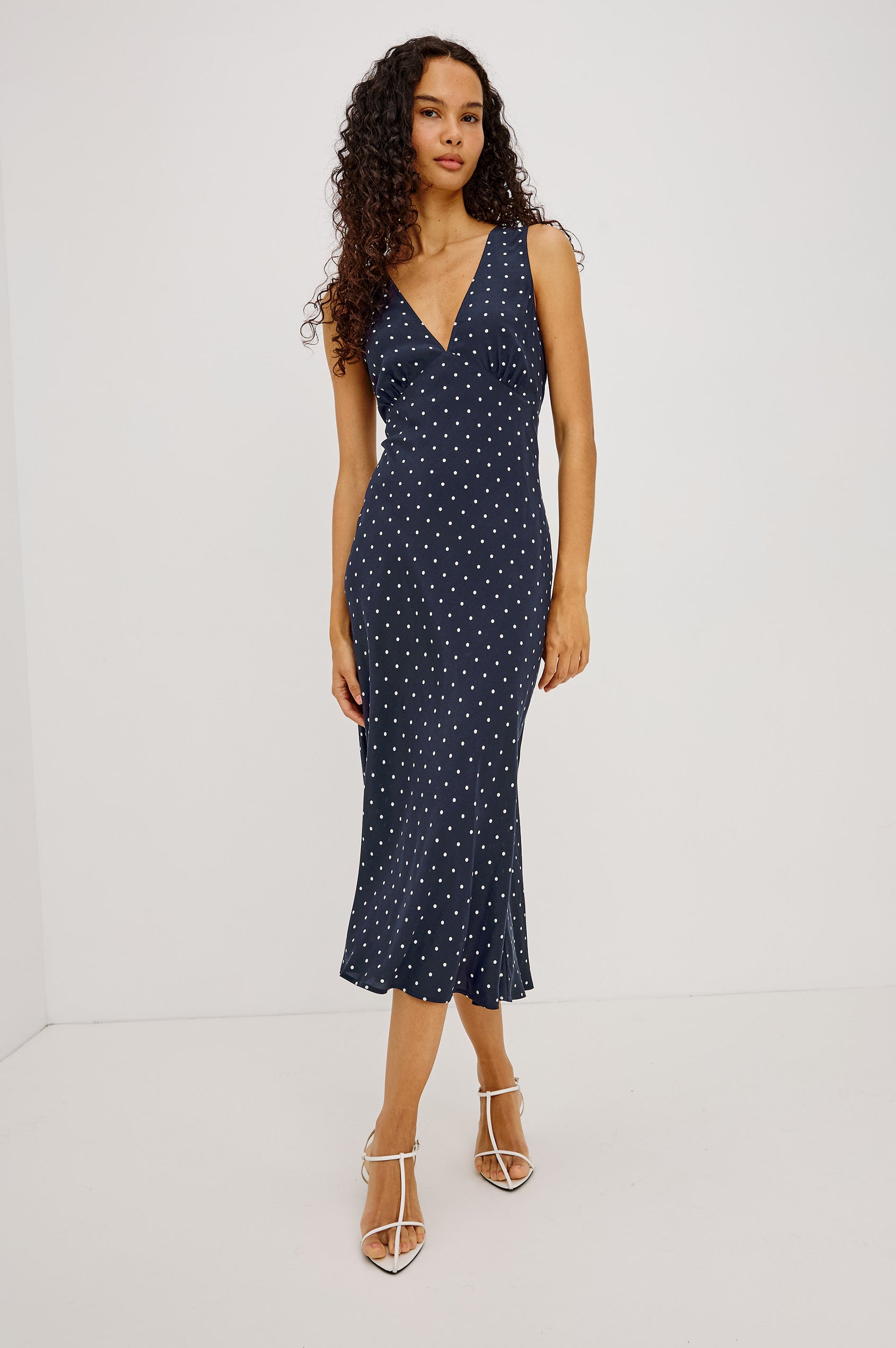 Audrina Midi Dress in Crepe Blend Bias Cut With Plunging V-Neckline in Navy Polka Dots Colorway - Full Body Front View Featured on Model